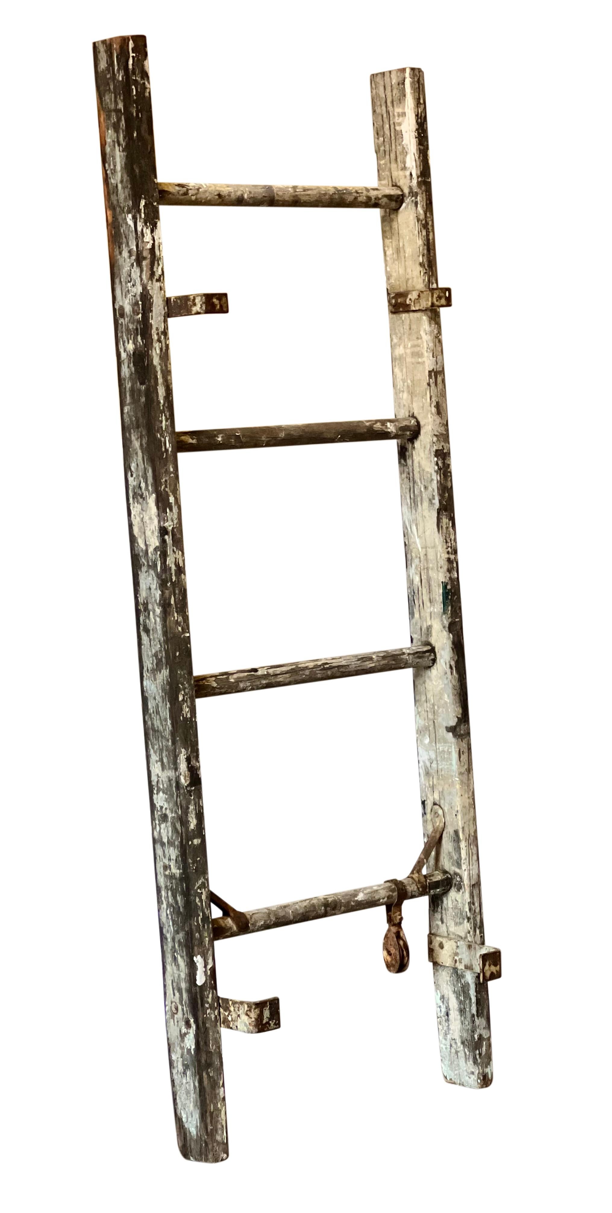 Antique rustic primitive wood ladder, c. 1910-1920.

Charming, weathered ladder with original paint in shades of white and gray with hints of pale blue, green and yellow.. It retains the original hardware and may have been a section of a painter's