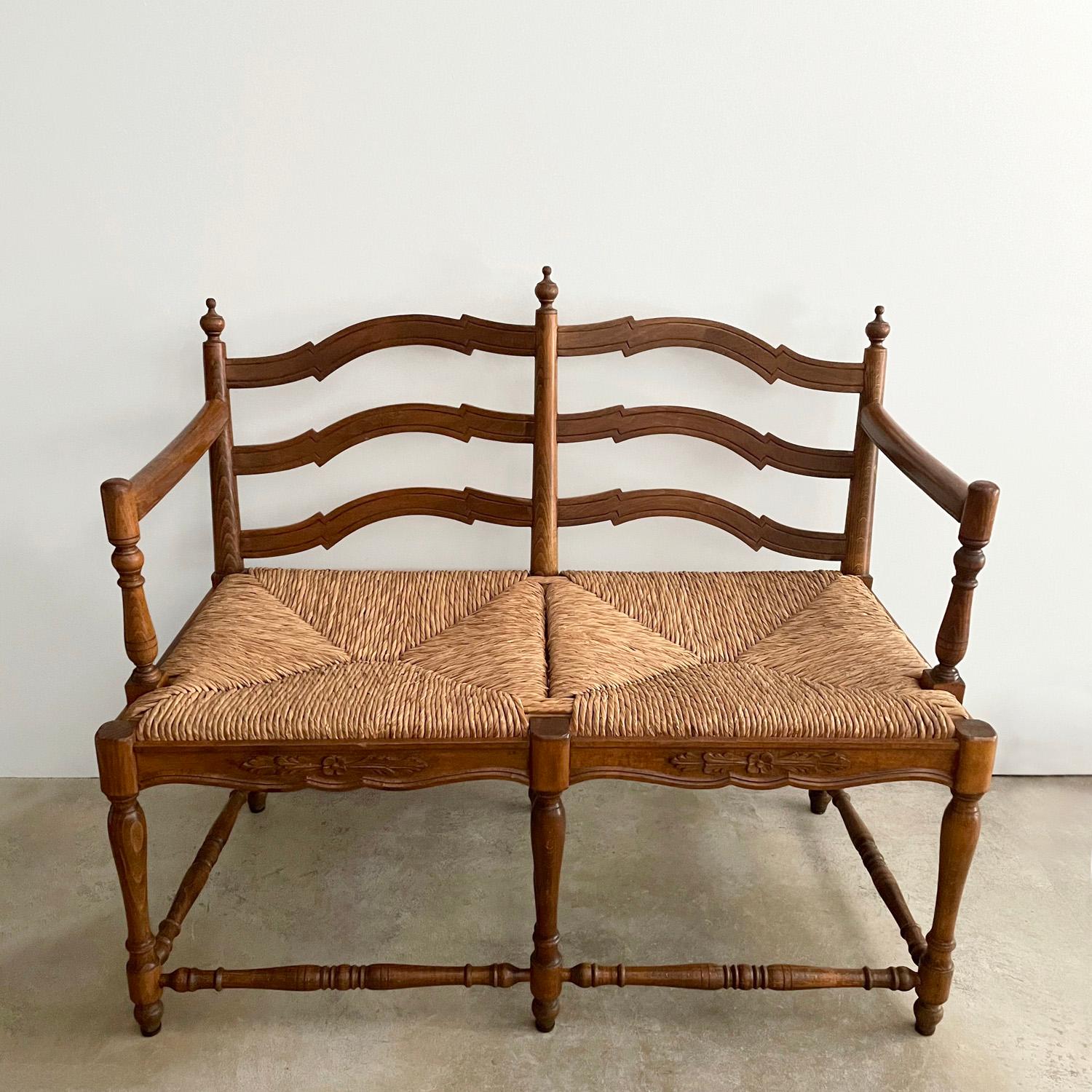 Antique rustic wood settee bench
Darling woven rush two-seater settee bench 
Wonderful attention to details throughout 
Solid wood frame has carved wood detailing and is finished with delicate turned wood finials
Seat base has carved floral motif