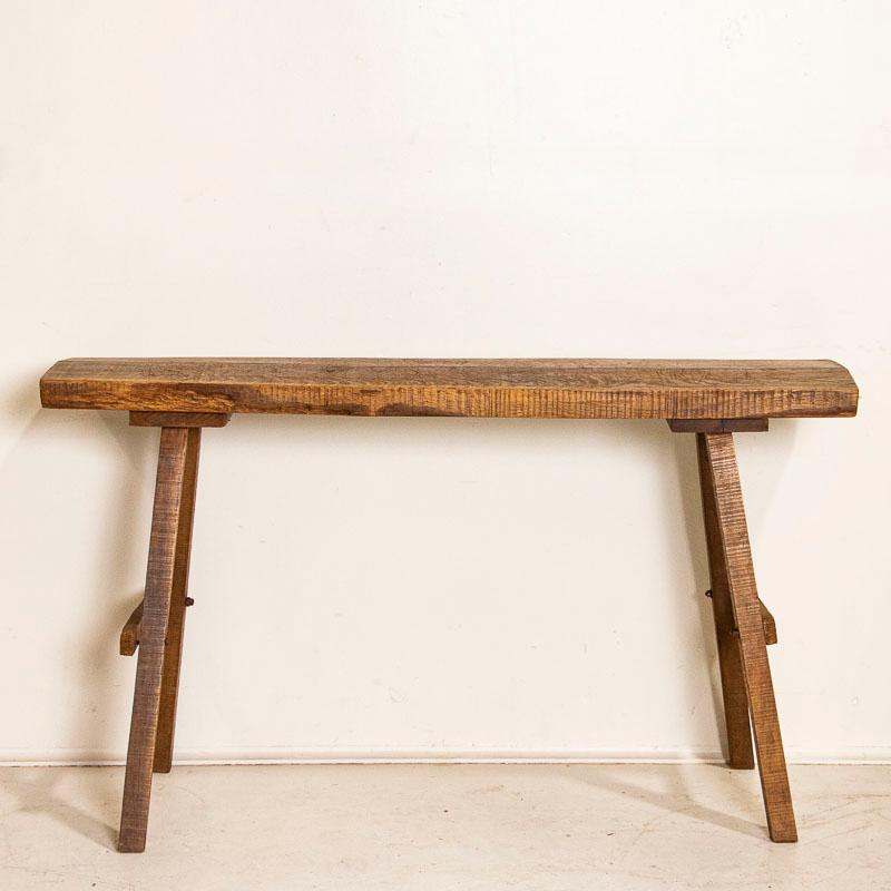 It is the knots, gnarls and old cracks that create the character in this rustic console table. The heft of the slab wood top draws one to it, but it is the deep gouges, marks, cracks and distress that make it so unique. Originally, this was likely a