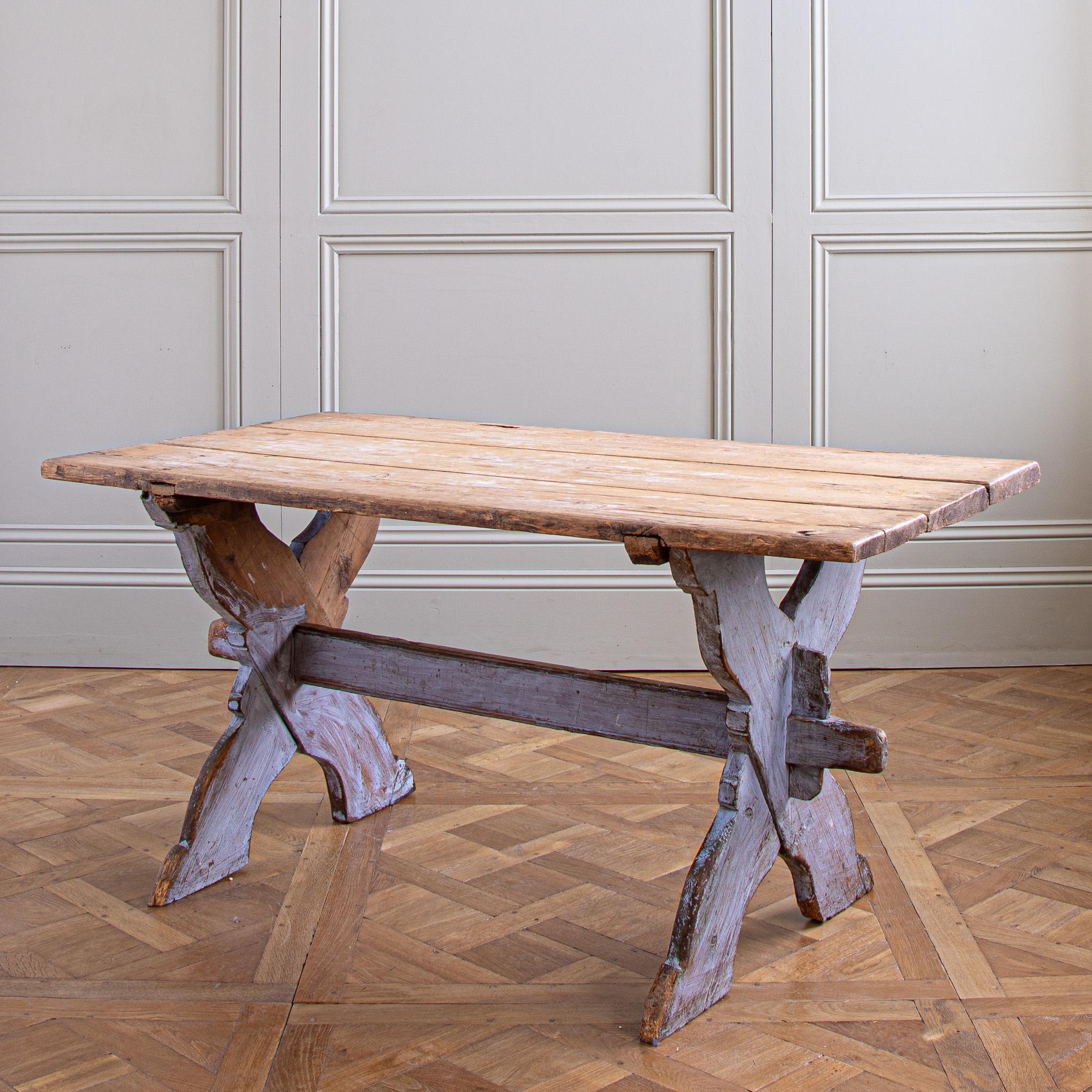 An antique Swedish farm house table, Circa 1860. Hand made in solid, European pine, wood. It has a naturally, age-textured, blond -wood top on an elegant cross frame which has a lovely bold and animated, Swedish blue, chalk-paint wash. The piece