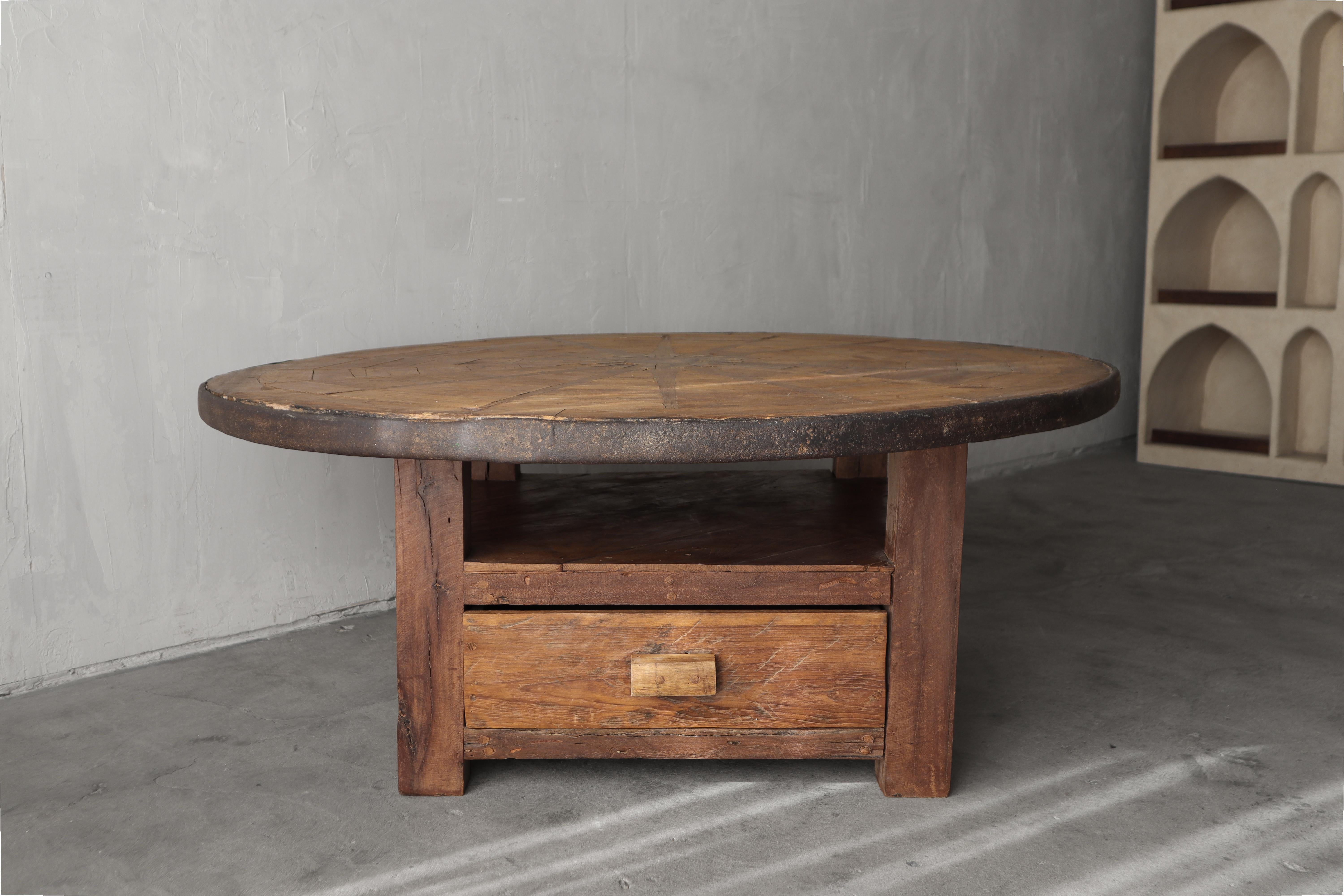 Si le style wabi et rustique est votre style de décoration, cette table basse en forme de roue de wagon antique se sentira comme chez elle.   Une belle pièce d'antiquité transformée en meuble fonctionnel.  La table comporte un tiroir fonctionnel de