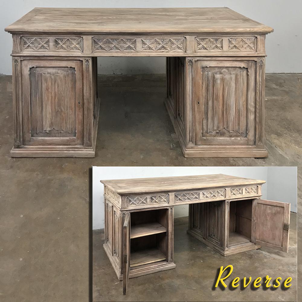 Antique rustic whitewashed pine gothic partners desk represents an understated example of the style, with linenfold panels all around, and cabinets on both sides with a kneehole that goes completely through so two can work at the same desk