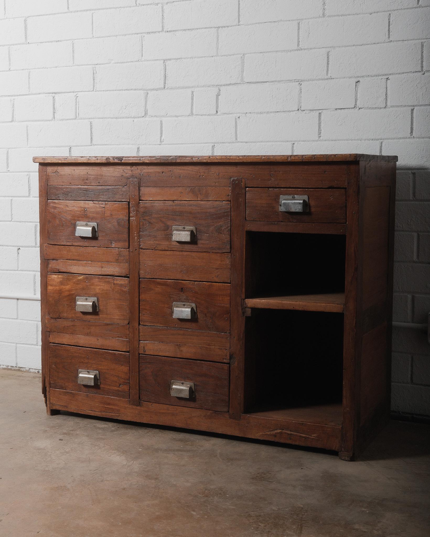 This antique wooden apothecary cabinet exudes rustic charm and industrial appeal, making it a stunning statement piece for vintage-inspired interiors. Crafted from solid wood, the cabinet features a beautifully aged patina with visible grain