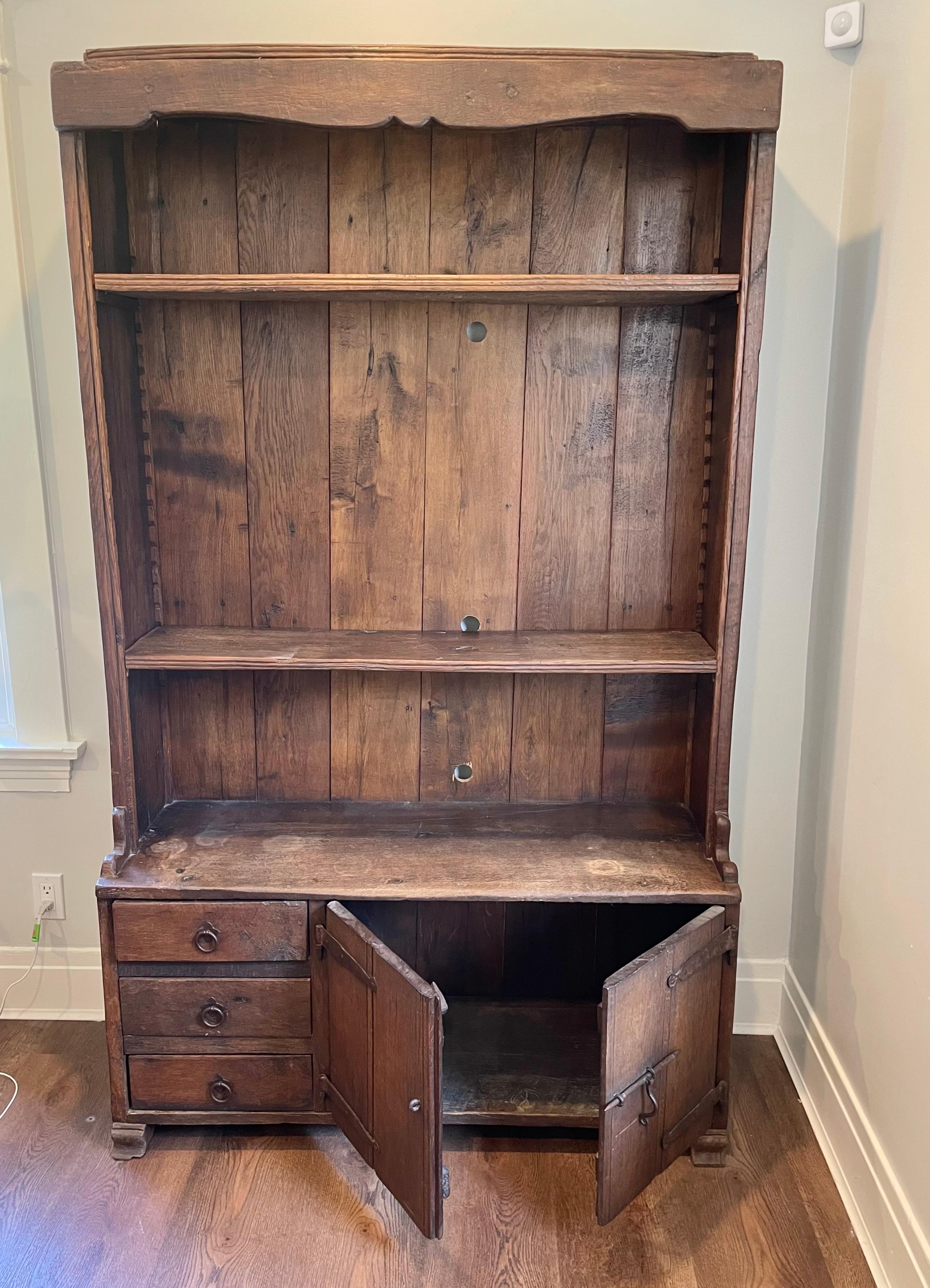 Un'antica e sorprendente credenza in legno rustico, probabilmente pino, con ferramenta in ferro, risalente alla fine del XIX secolo. In questo pezzo vediamo la sensibilità degli artigiani americani, così come gli echi del movimento Mission nelle