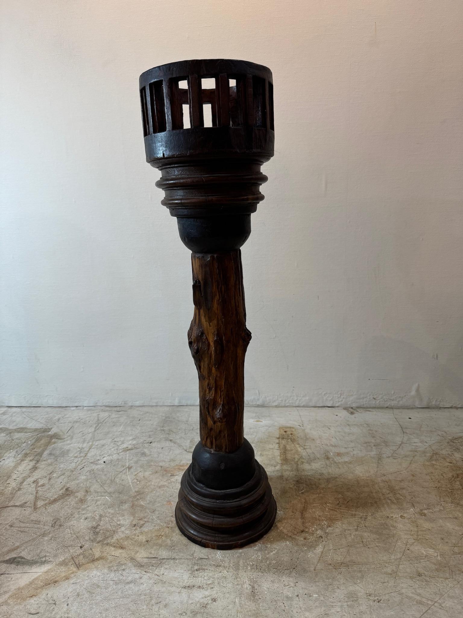Questo esclusivo portapiante in legno antico presenta un design rustico e consumato dal tempo con una caratteristica base ispirata all'asse della ruota. Realizzato in legno massiccio, presenta una patina invecchiata, usura naturale e scheggiature