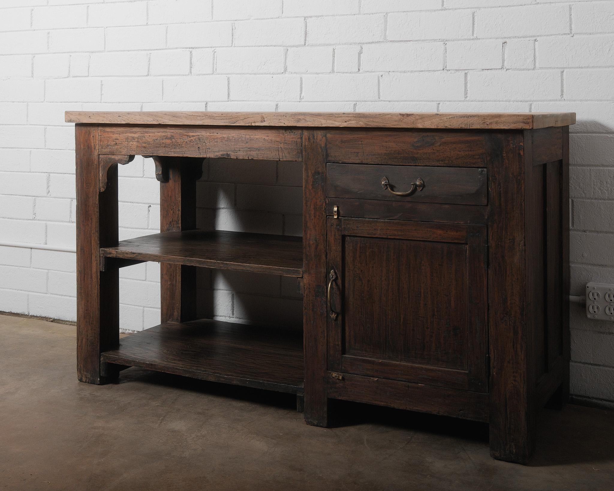 This antique rustic wooden workbench console table is an exquisite 19th-century farmhouse piece, blending functionality with character. Crafted from solid wood, the table features a beautifully aged patina with a contrasting two-tone finish— a