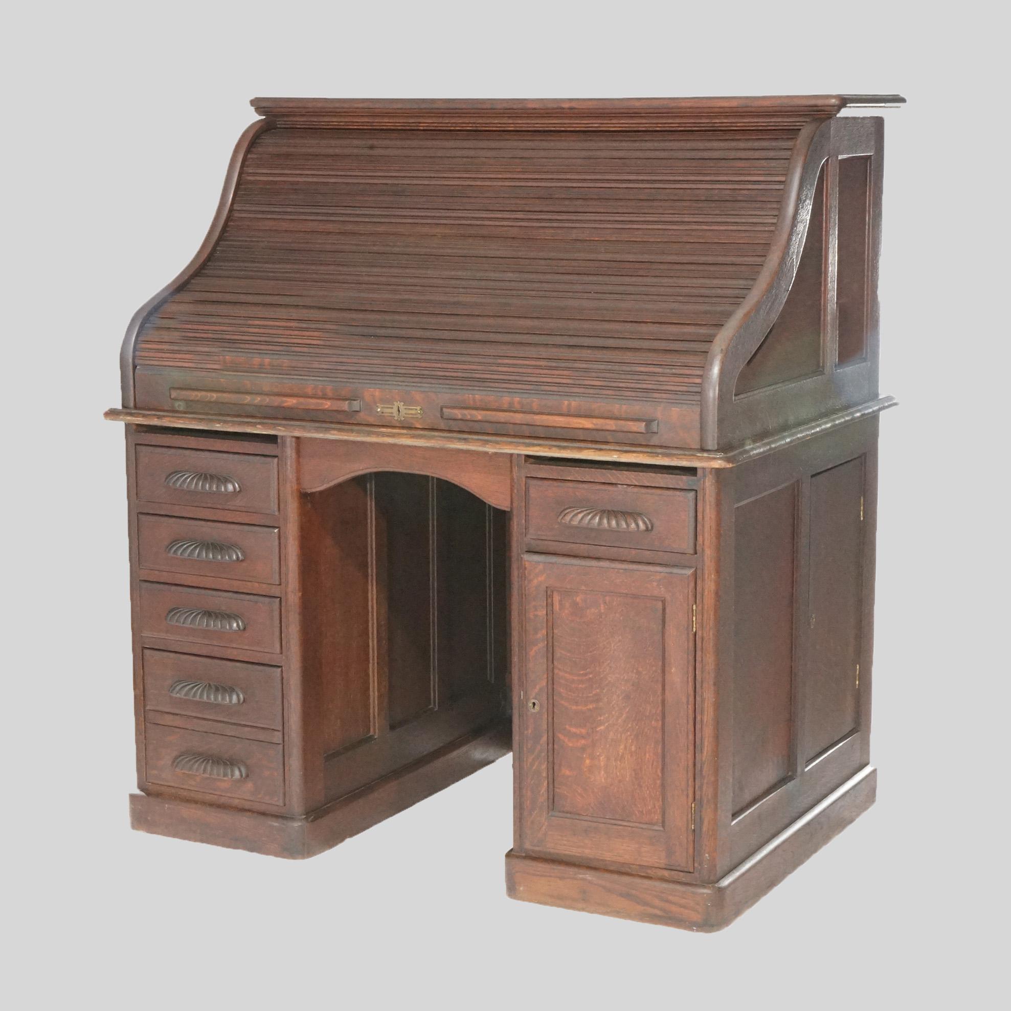 An antique desk offers oak paneled construction with s-roll top opening to full interior over base having drawers and cabinet, circa 1900.

Measures- 52.5''H x 48''W x 32.75''D.