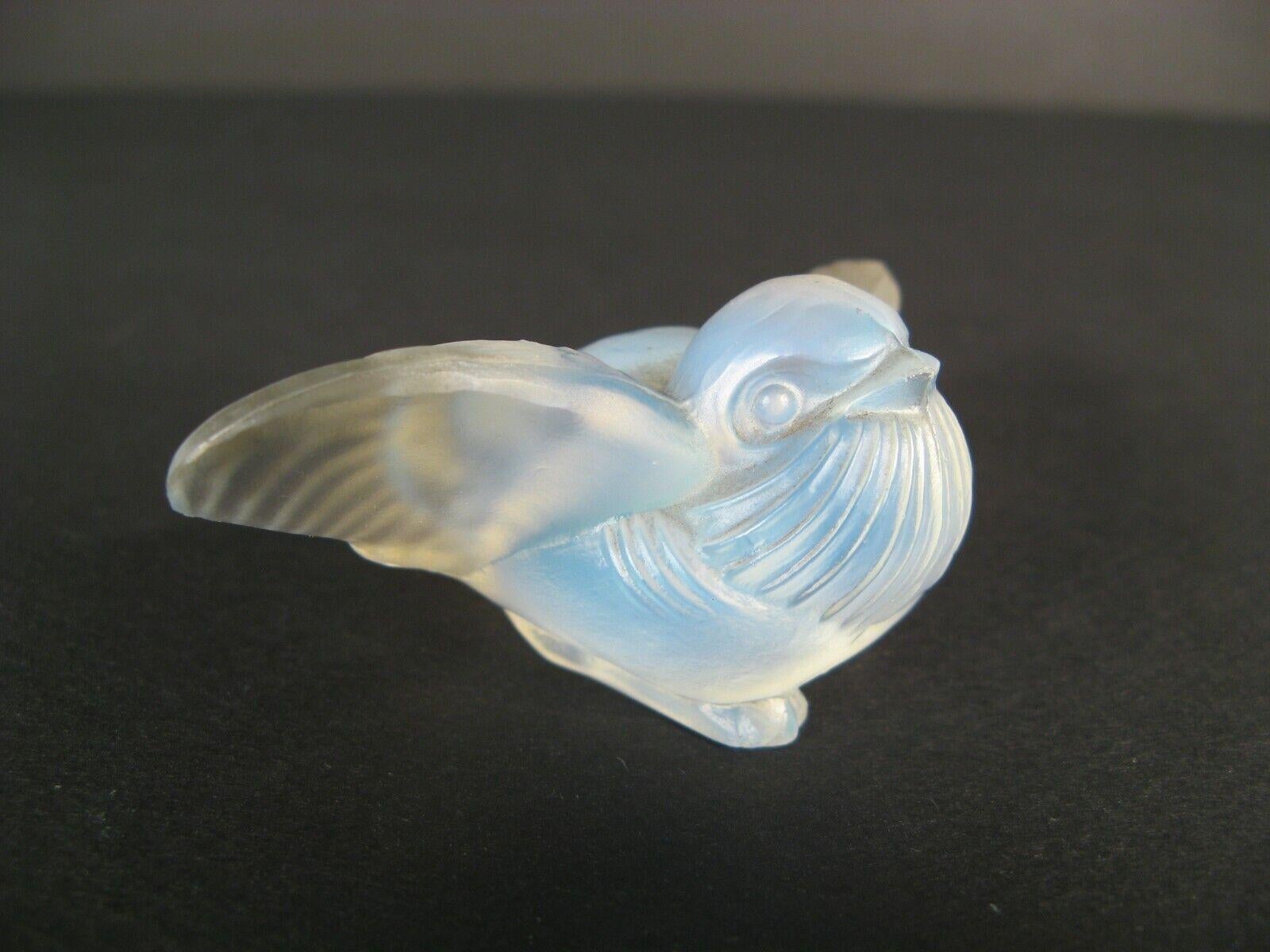 This exquisite antique figurine, crafted from opalescent molded glass by Sabino France, depicts a charming bird with outstretched wings. Created in the mid-20th century, this piece is a fine example of Sabino's renowned artistry and delicate
