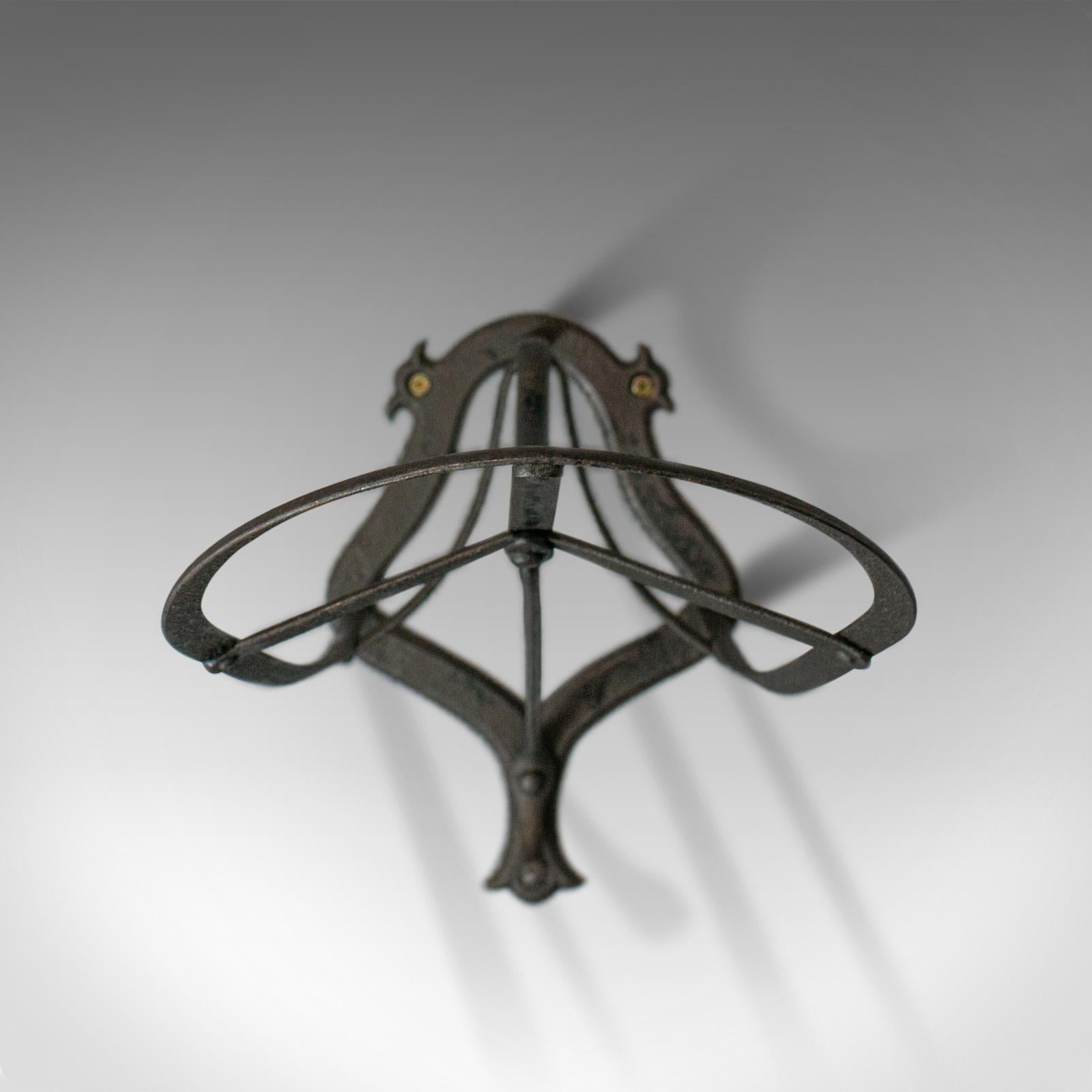 This is an antique saddle rack. An English, Victorian wall-mounted, forged iron rack dating to the turn of the 20th century, circa 1900.

Forged in iron with graphite finish for durable equestrian needs
Good consistent color with a desirable
