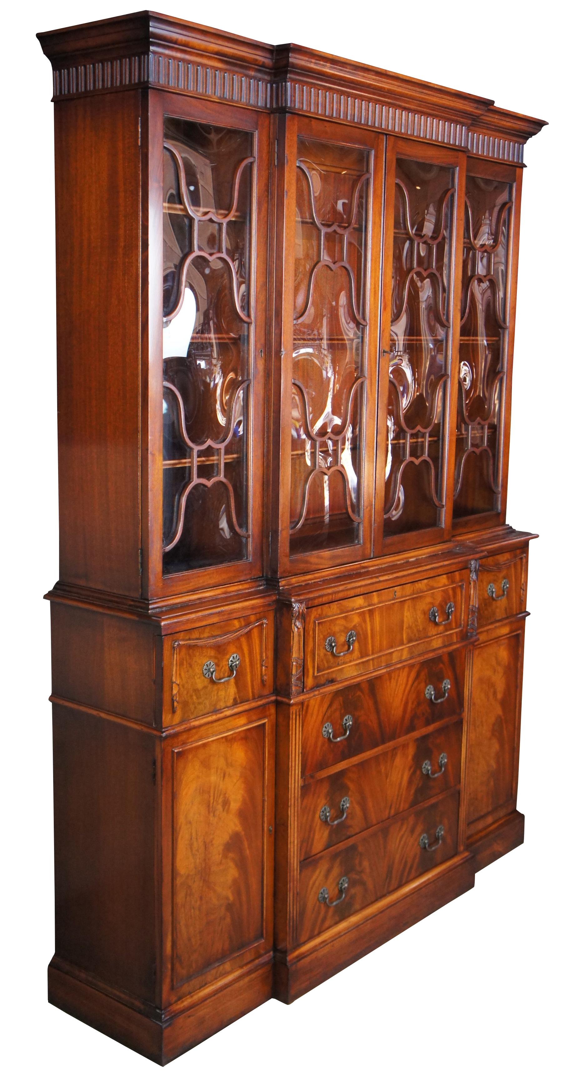 Antique Saginaw Furniture flame mahogany breakfront china cabinet featuring Neoclassical styling with fretwork bubble glass doors, lower cabinet and drawers, and a drop front butlers writing secretary or desk with tooled leather top and cubbies for