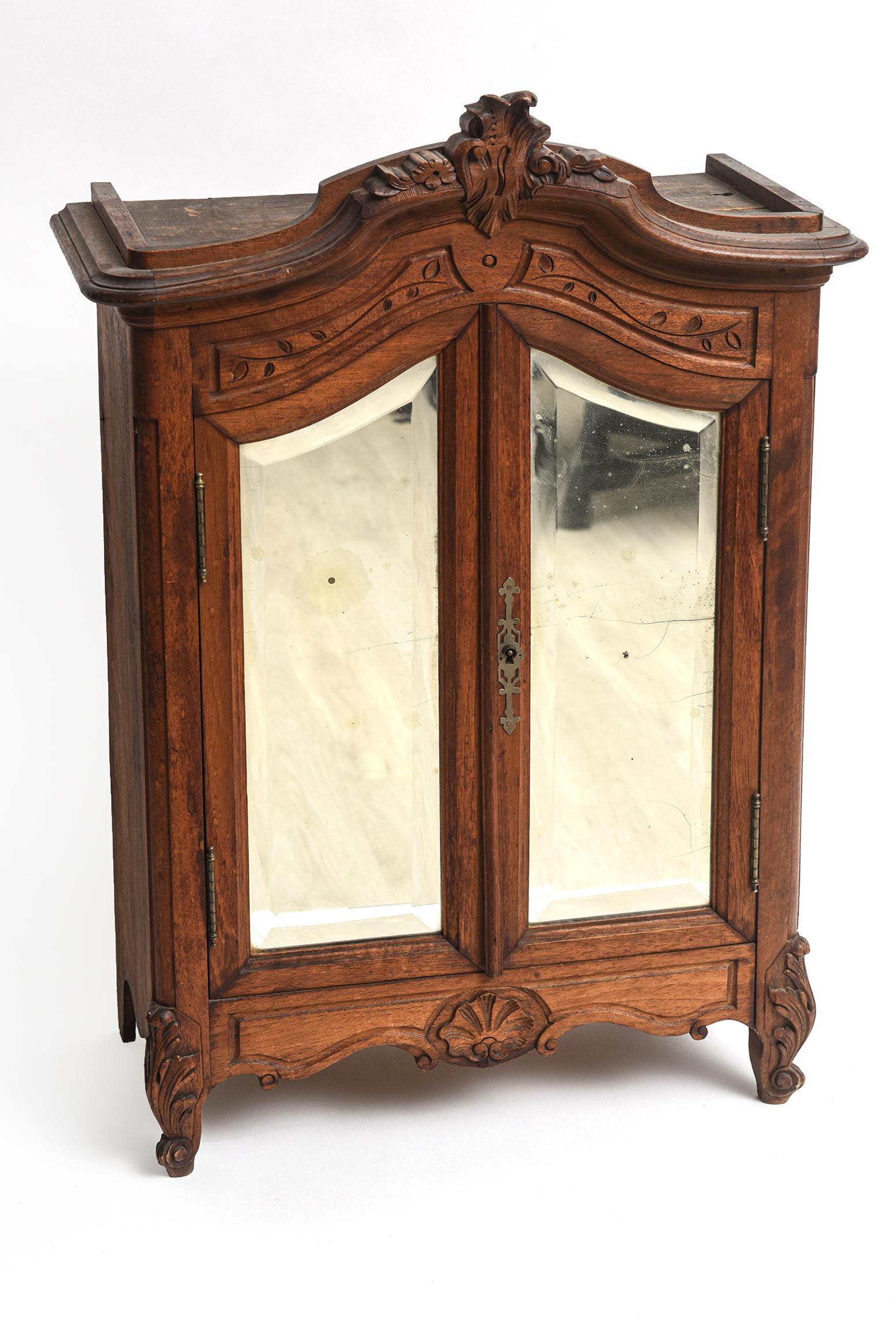 19th Century Victorian miniature armoire used by salesman to show their wears back in the olden days. This cabinet features a pair of double mirrored doors that open up to reveal two areas were you can put folded items. Perfect as a display or to be