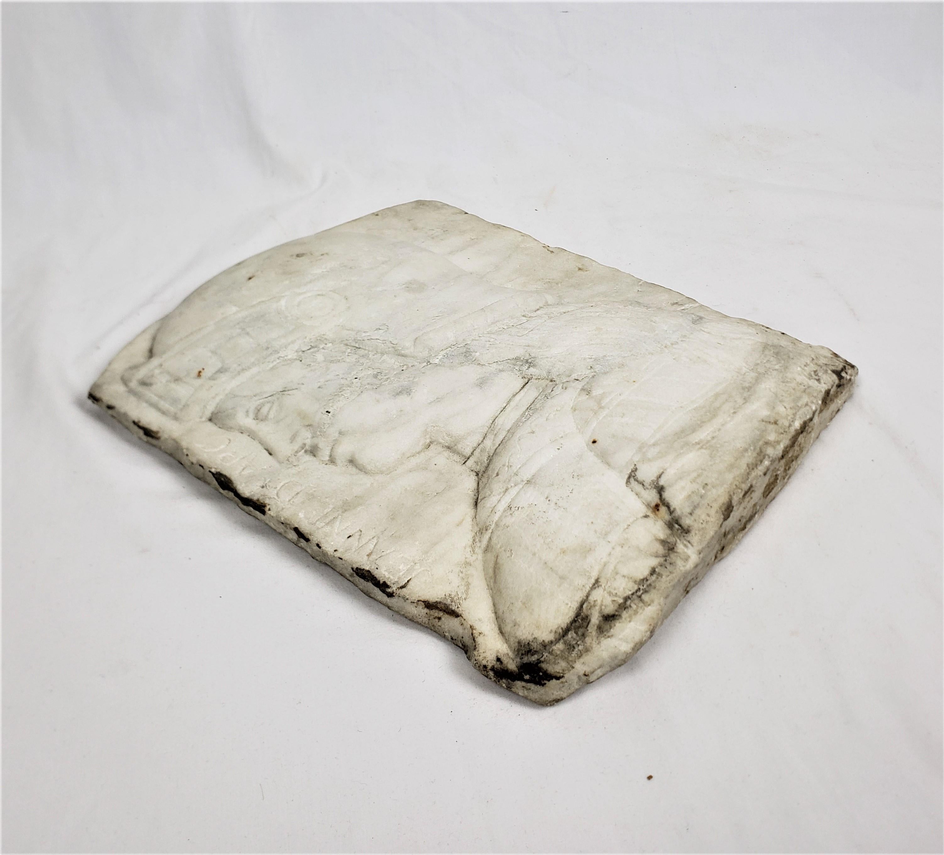 This salvaged carved architectural element is unsigned, but presumed to have originated from France and date to approximately 1835 and done in a Neoclassical style. This antique fragment is done with a slab of carrera marble and depicts the facial
