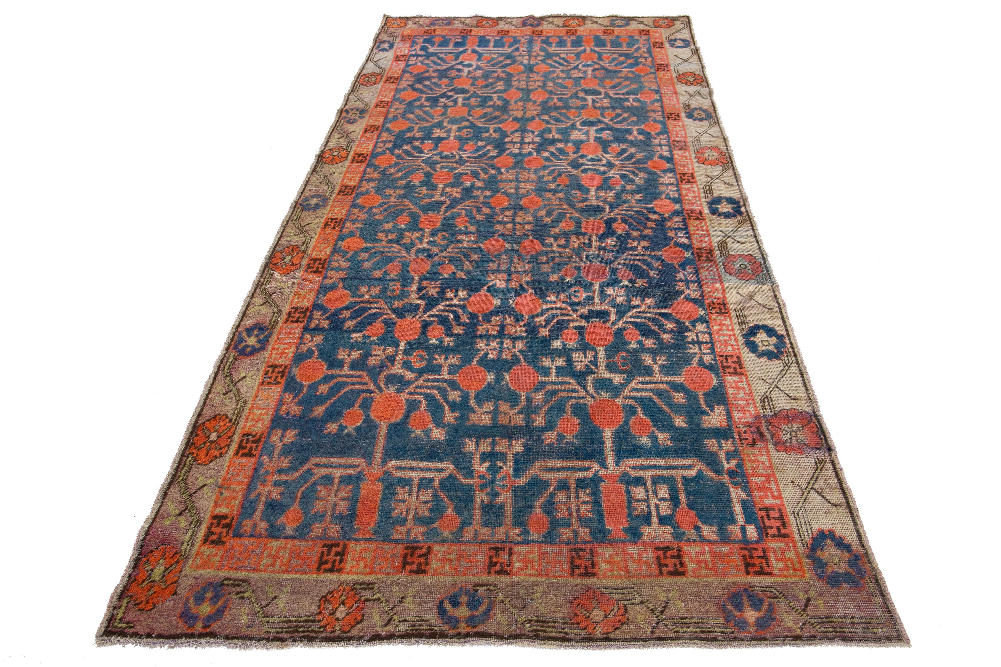 Il s'agit d'un superbe tapis ancien en laine nouée à la main de Samarkand, ton sur ton, avec un champ bleu marine. Il présente des accents beiges et rouille à travers un magnifique motif de rosette de grenades interconnectées.

Ce tapis mesure 4'10