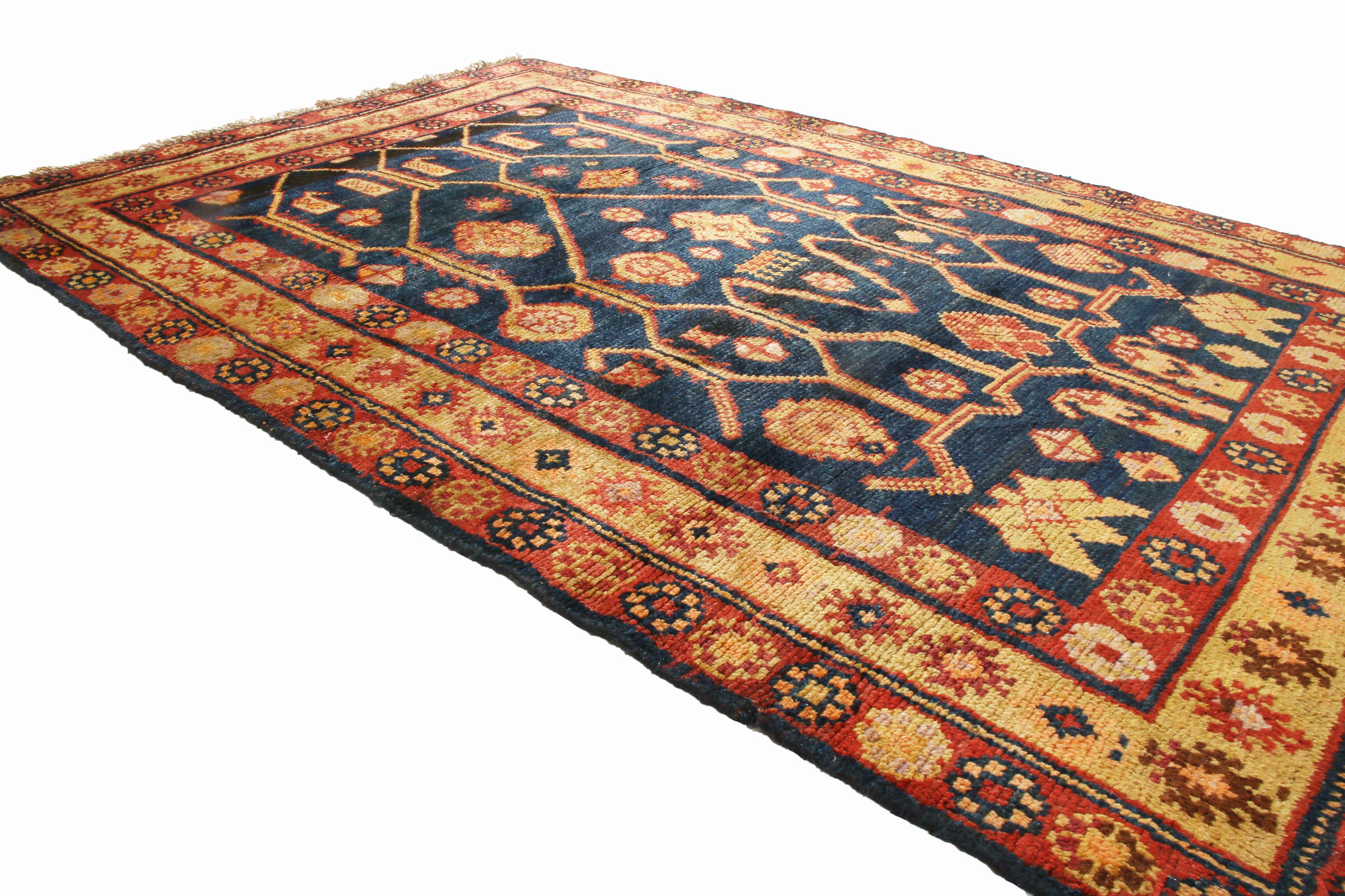 Originating from East Turkestan, this antique traditional Samarkand wool rug features a distinguished field design with an intriguing combination of mirrored and asymmetric symbolism. Hand knotted in high quality, luminous wool, while the red and