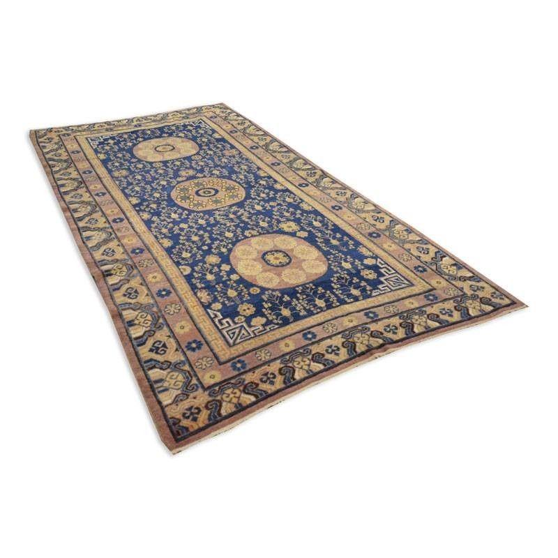 Samarkand rug from the ancient Silk Road.
- Antique rose window design on a blue background with influences from Chinese rugs.
- Design of flowers and branches intertwined with three rosettes presiding over the central field.
- Its origin comes both