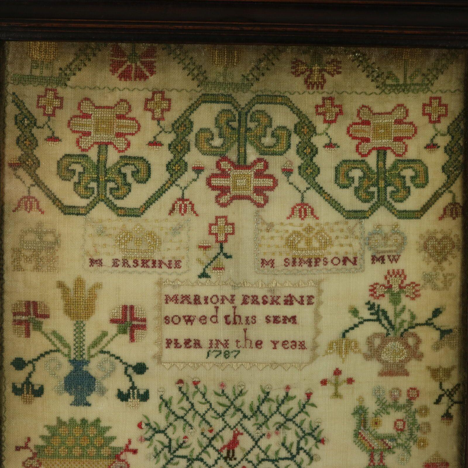 Georgian Sampler, 1787, by Marion Erskine. The sampler is worked in silk threads on a linen ground, mainly in cross stitch. Meandering floral border. Colours green, blue, red, gold, black, dark brown and silver. Family initials, 'IE, GE, RE, IS, IO,
