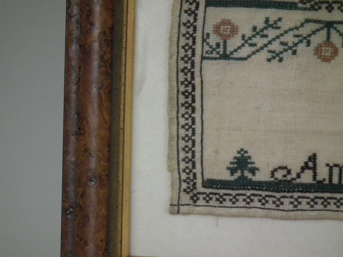 1834 'Knowledge' Sampler by Ann Kelk. The sampler is worked in silk on a linen ground, in a variety of stitches. Simple embroidered border. Colors black, cream, green and peach. Alphabets A-Z in upper case and lower case. Sampler entitled