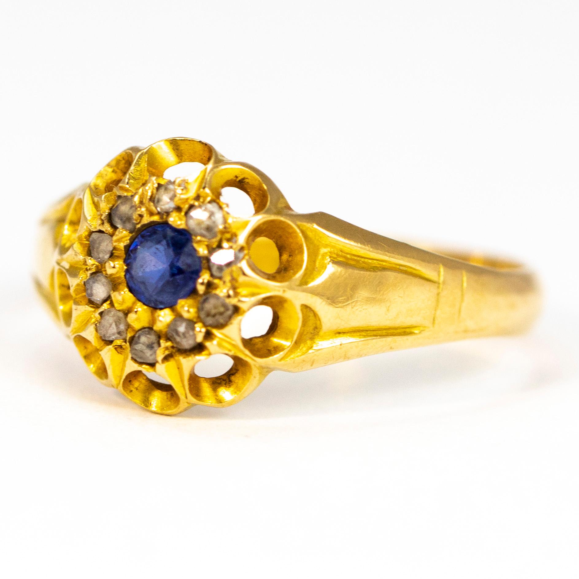 This delicate cluster ring holds a sapphire and the centre measuring 15pts and surrounding it is a halo of Diamonds measuring 2pts each. The metal work around the stones holds lovely looped detail which carries on down to chunky shoulders. 

Ring