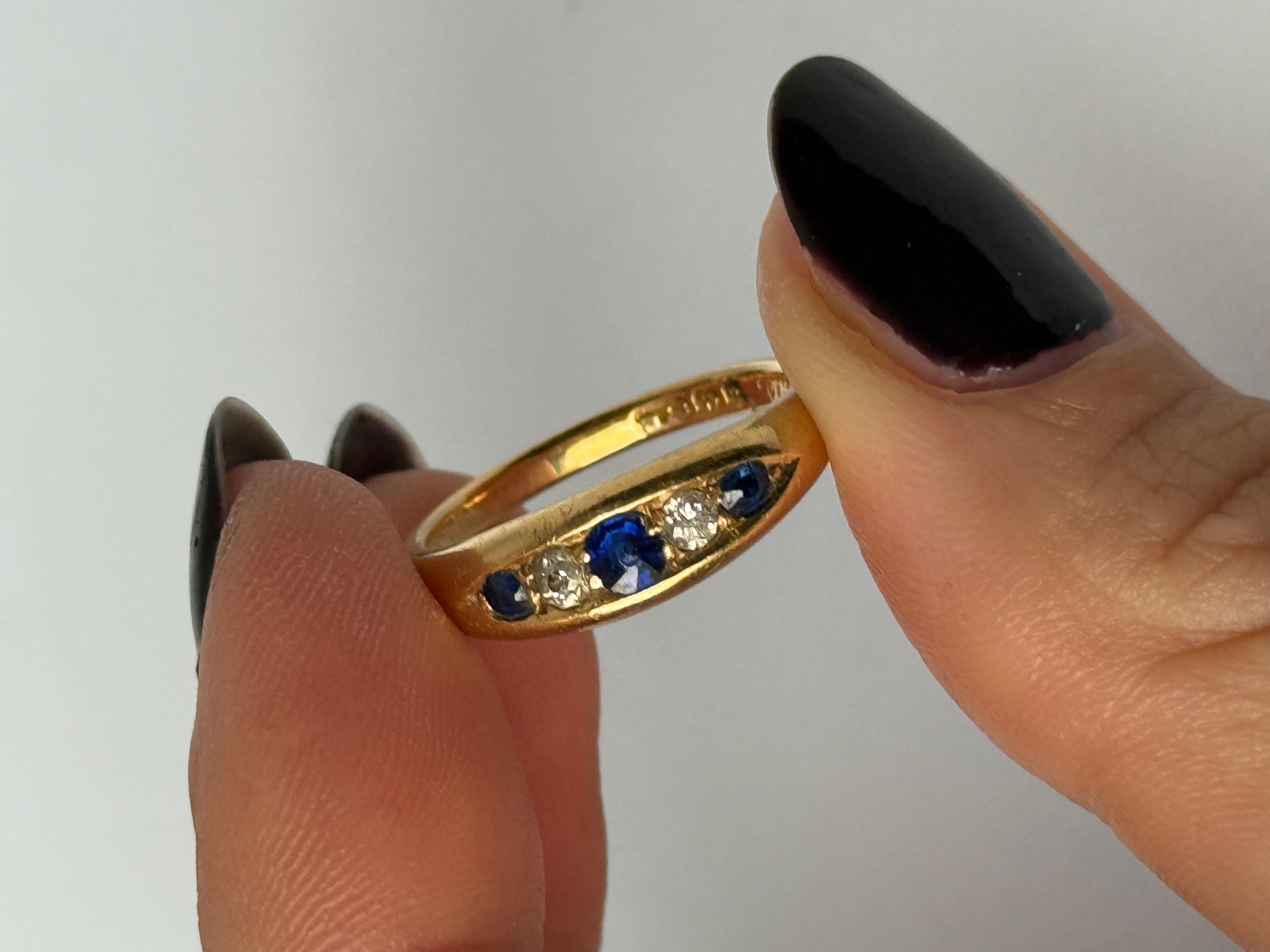 All'interno dell'oro sono incastonati tre splendidi zaffiri blu per un totale di circa 20 carati. Tra gli zaffiri si trovano due brillanti. Il diamante ha un totale di 10 punti. L'anello è realizzato in oro 18ct. Completamente marcato Birmingham