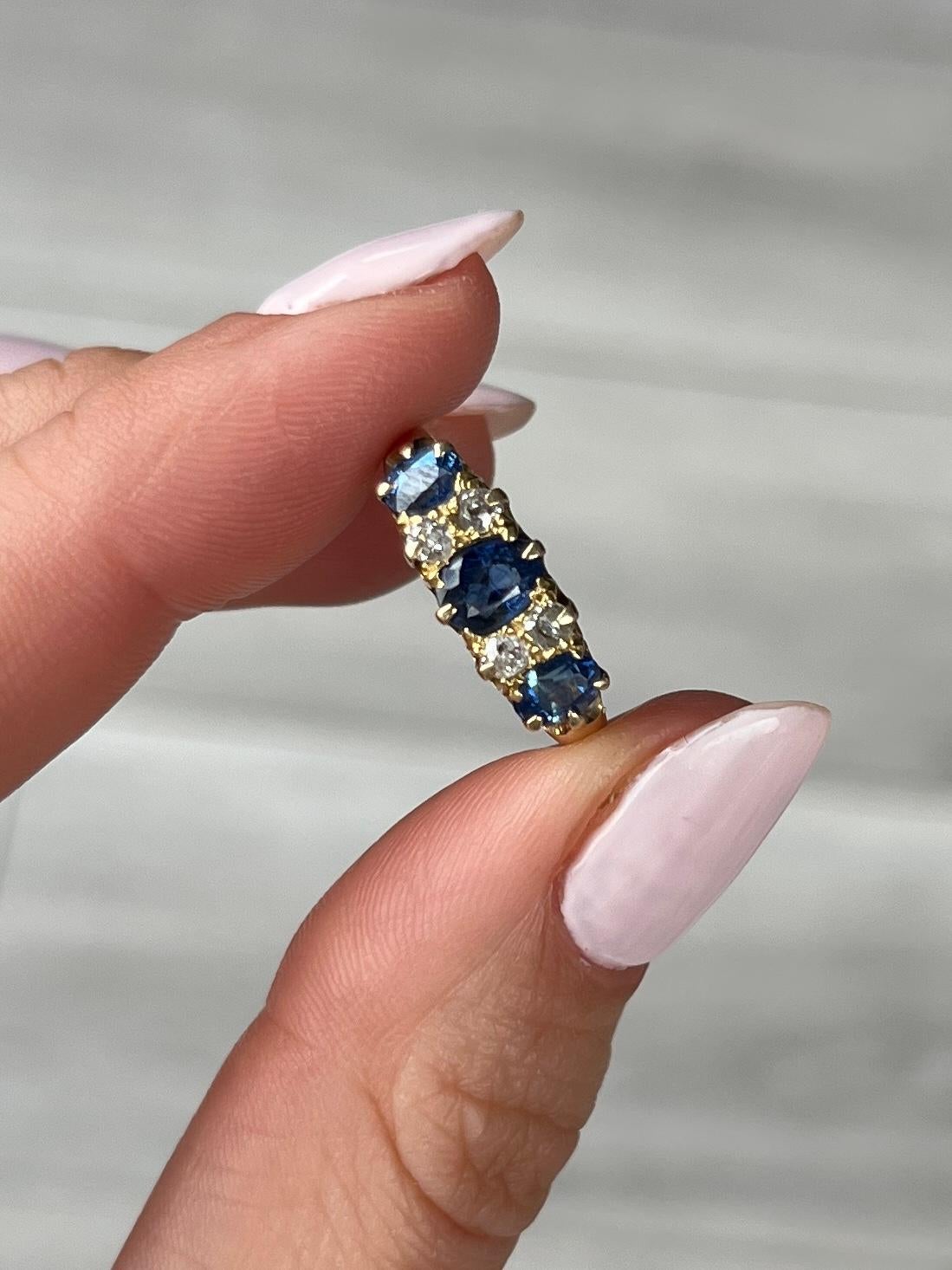 This gorgeous ring dates to the early 1900's and holds three inky blue sapphires. The central sapphire measures 50pts and the ones either side measure 25pts each. In between the blue stones are pairs of diamonds measuring 8pts per pair. The ring is