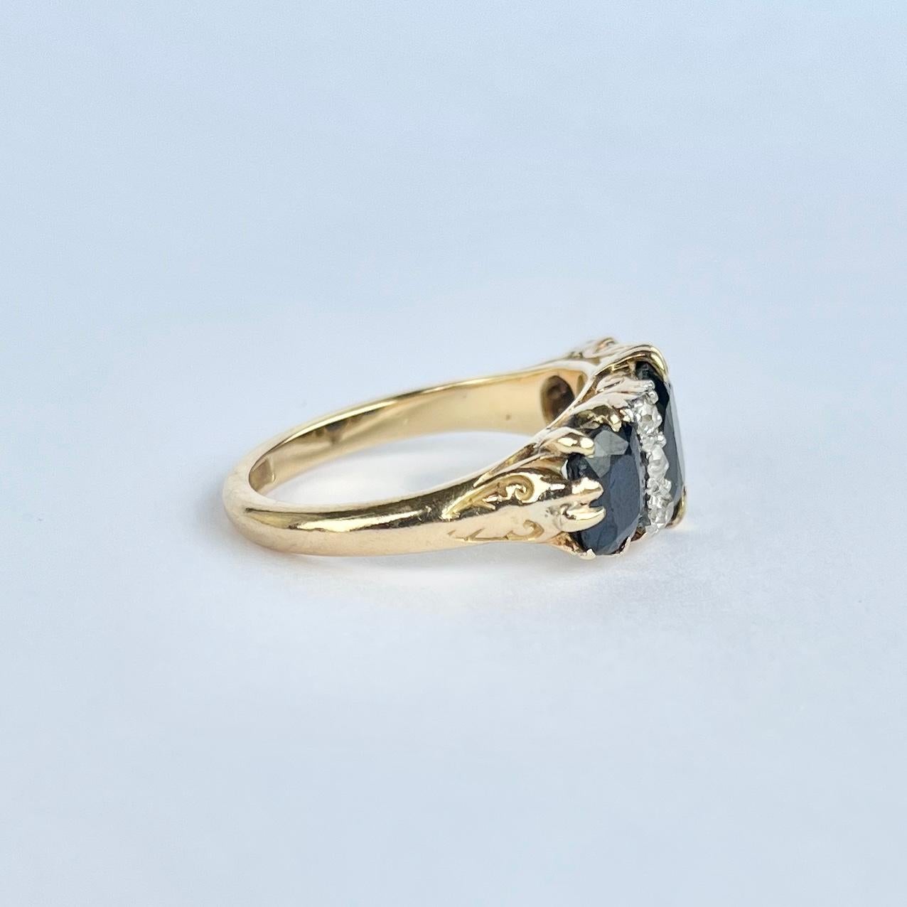 This gorgeous ring dates to the early 1900's and holds three inky blue sapphires. The central sapphire measures 1ct and the ones either side measure 50pts each. In between the blue stones are trios of diamonds measuring 15pts per trio. The ring is