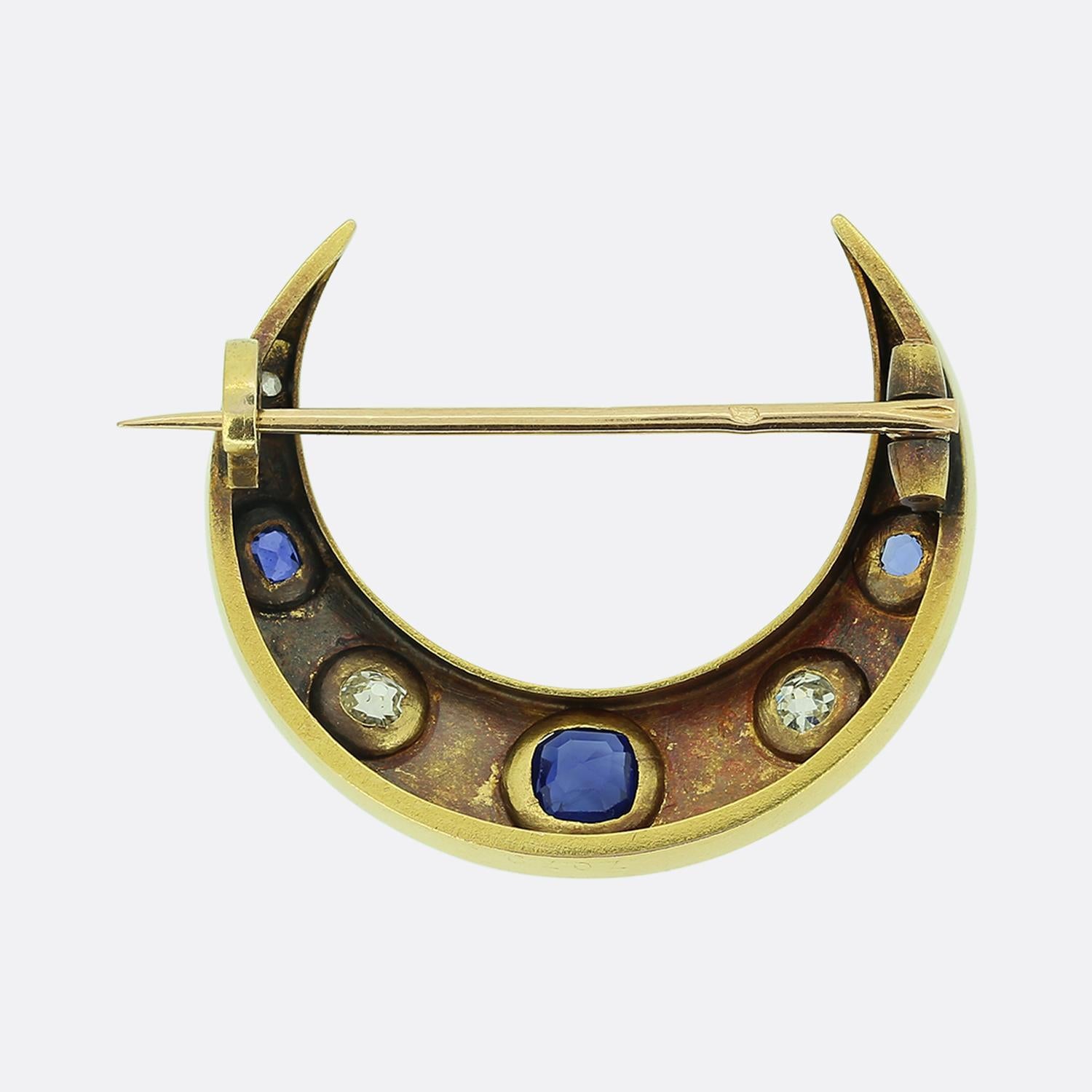 Here we have a delightful sapphire and diamond set brooch from the later stages of the 19th century. This gorgeous piece has been crafted from a rich 18ct yellow gold into the shape of a crescent moon which plays host to an alternating array of