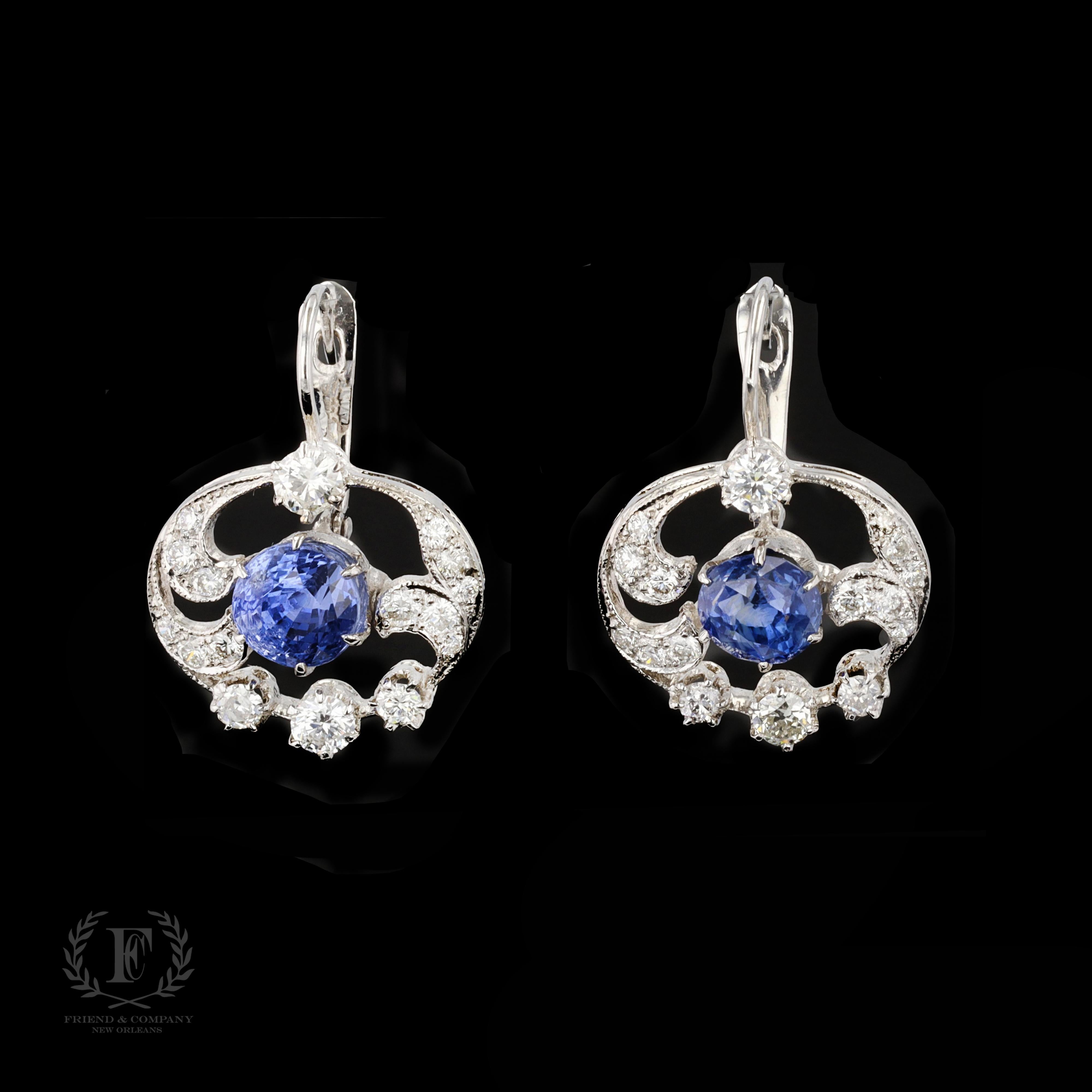 Spectacular round cut diamonds and round cut sapphires sparkle in these elegant 18 karat white gold drop style earrings. Featuring French style backs, the earrings contain 4.30 carats of round cut sapphires and 1.33 carats of round cut diamonds. The