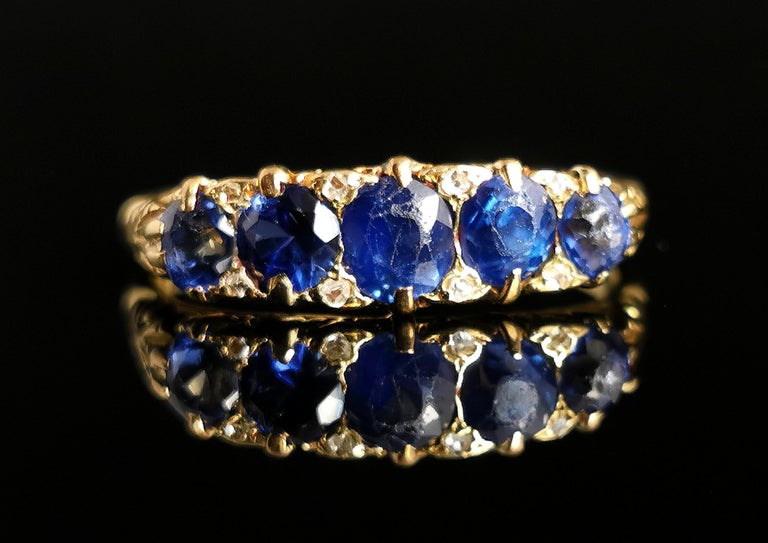 A stunning antique, late Victorian era Sapphire and Diamond five stone ring.

Five vibrant and rich blue sapphires fill up the face with plenty of presence, there are diamond point spacers above and below giving a little sprinkle of sparkle amongst