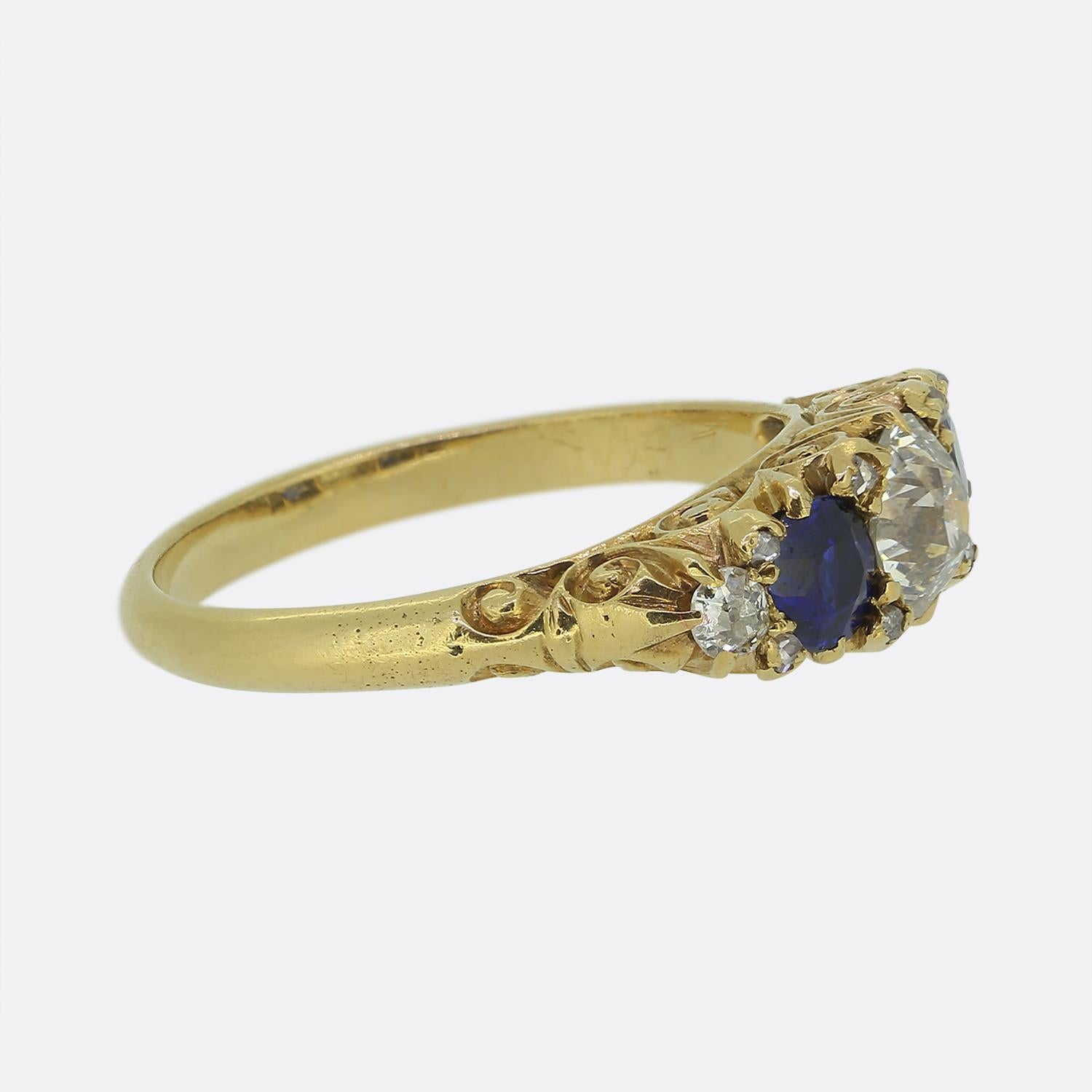 Ecco un antico anello con cinque pietre risalente alla fine dell'epoca vittoriana. Un diamante rotondo taglio antico si trova al centro ed è affiancato ai lati da un ricco zaffiro blu e da un diamante più piccolo taglio antico. L'anello è rifinito