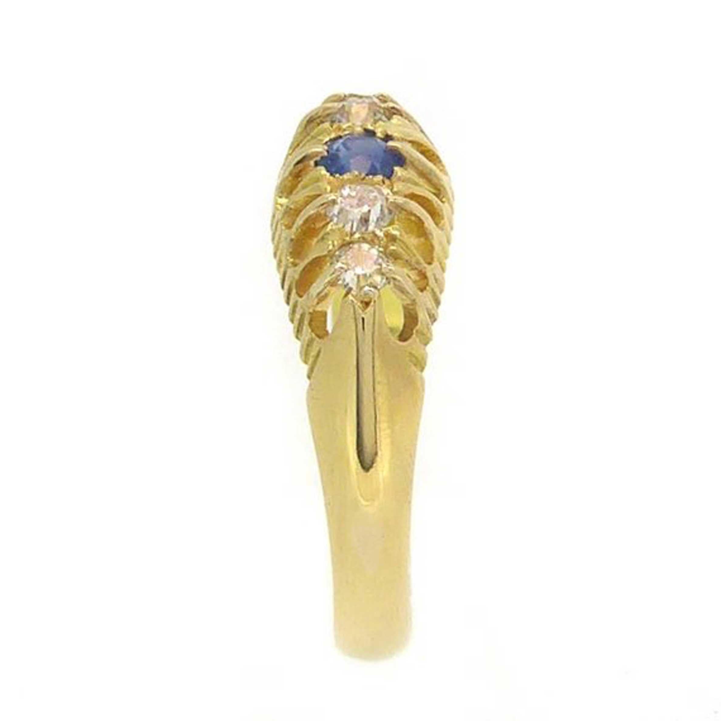 Set to the centre with a round sapphire of gorgeous blue hue and flanked on each side by two old European cut diamonds, this a truly delightful old ring from the English George V era. Claw set above a pierced gallery the gemstones shimmer via the
