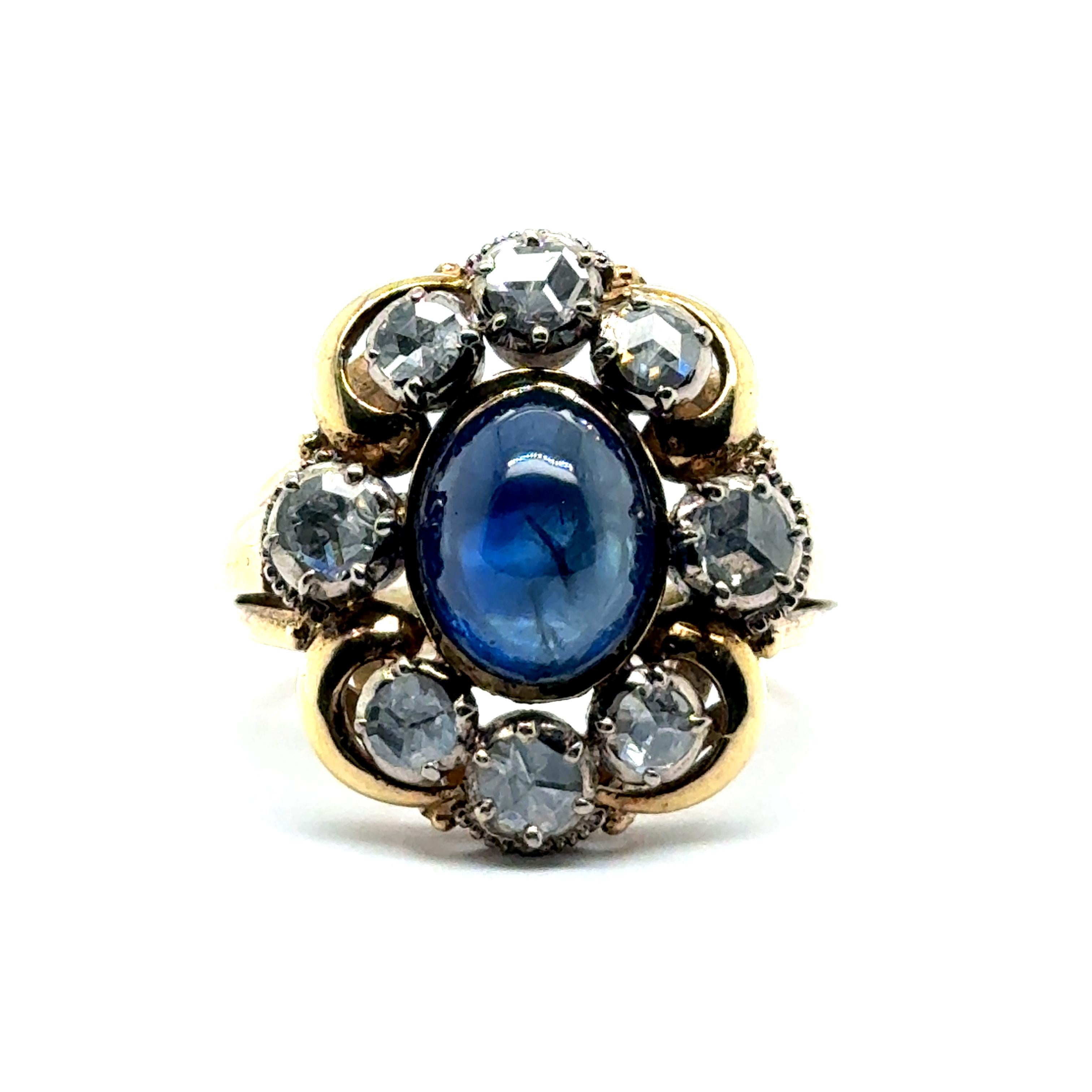 Entdecken Sie zeitlose Eleganz mit diesem antiken Ring aus 18 Karat Weiß- und Gelbgold. Mit einem faszinierenden blauen Saphir-Cabochon von insgesamt 4,30 Karat ist dieses Stück ein Zeugnis für raffinierten Geschmack und historischen Reiz. Acht