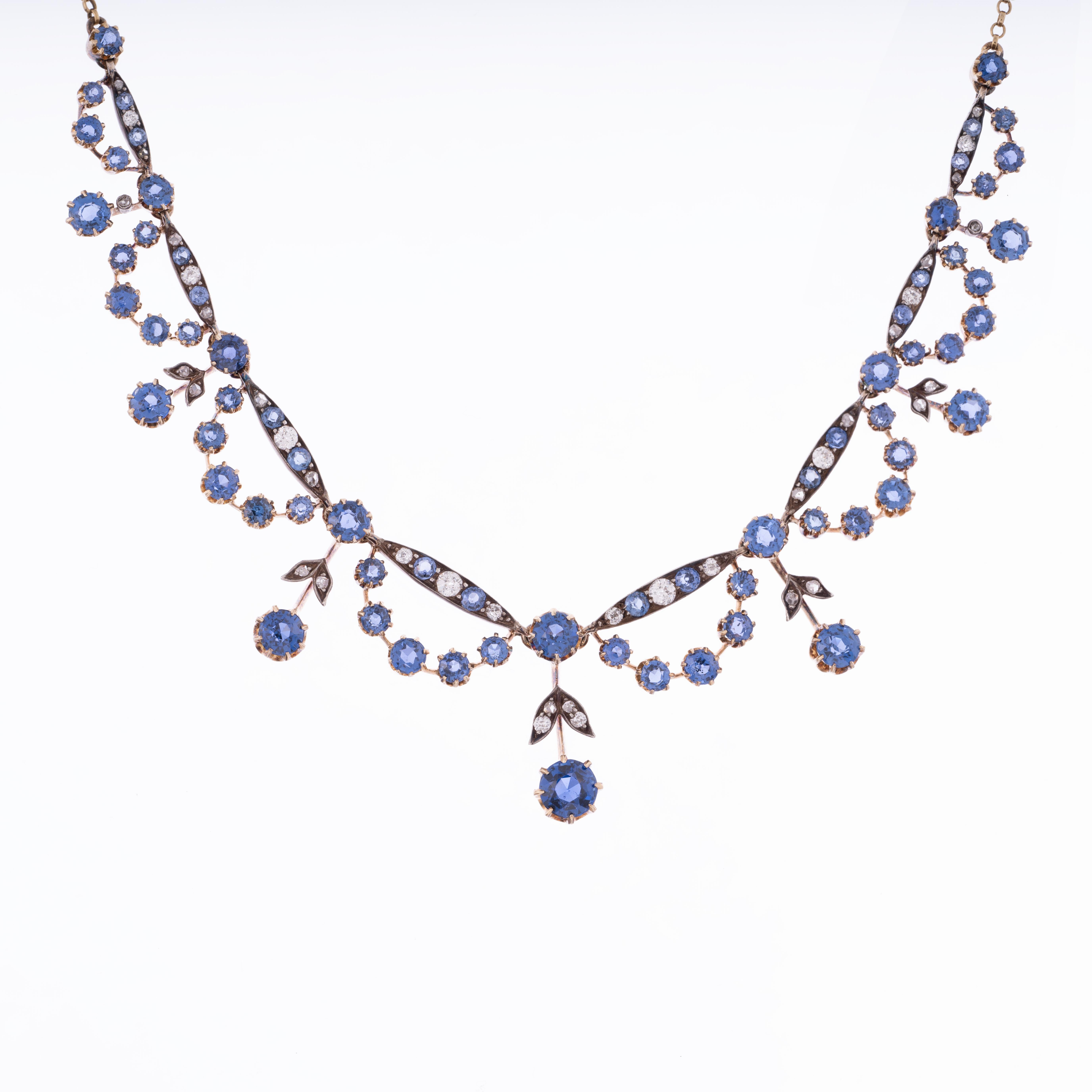 A truly special blue sapphire and diamond necklace from the Victorian era. The allure of this necklace is undeniable with lively gemstones displaying brilliant white light and flashes of blue dancing around the entire necklace. Featured are