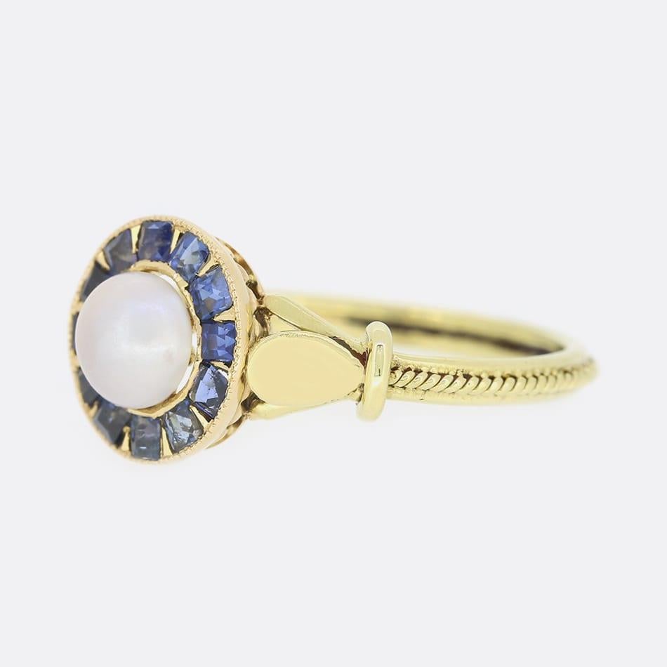This is an antique sapphire and pearl ring which has been set with a central pearl and surrounded by multiple calibre cut sapphires in a target shape.
The ring was masterfully converted from a Victorian brooch by the antique jewellery restorer