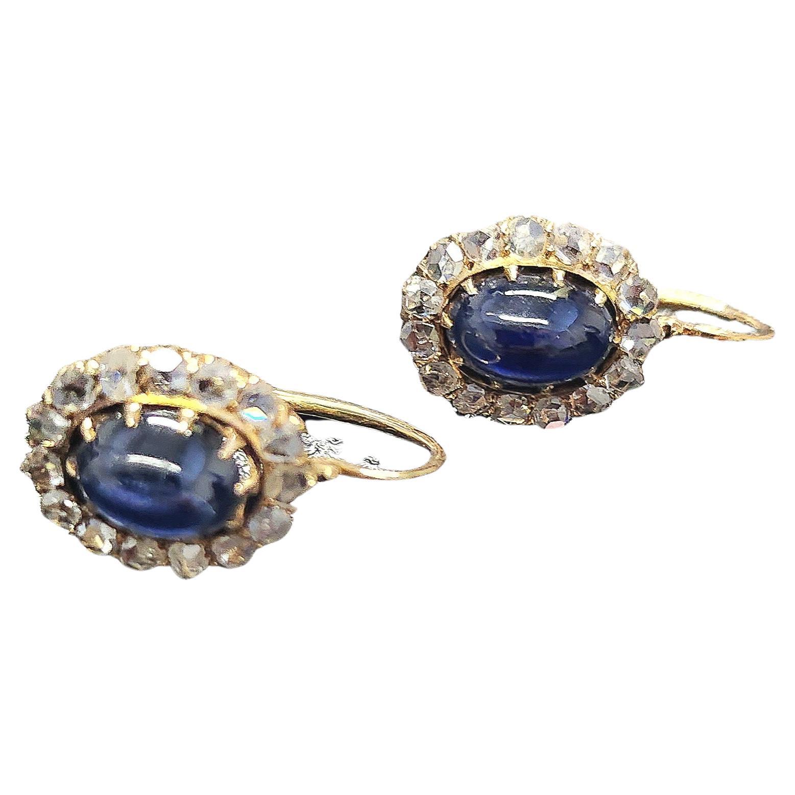 Antique earrings centered with oval cut cabouchon blue sapphire flanked with rose cut diamonds in 14k gold setting hall marked 56 imperial russian gold standard and later with 583 soviet gold control mark 