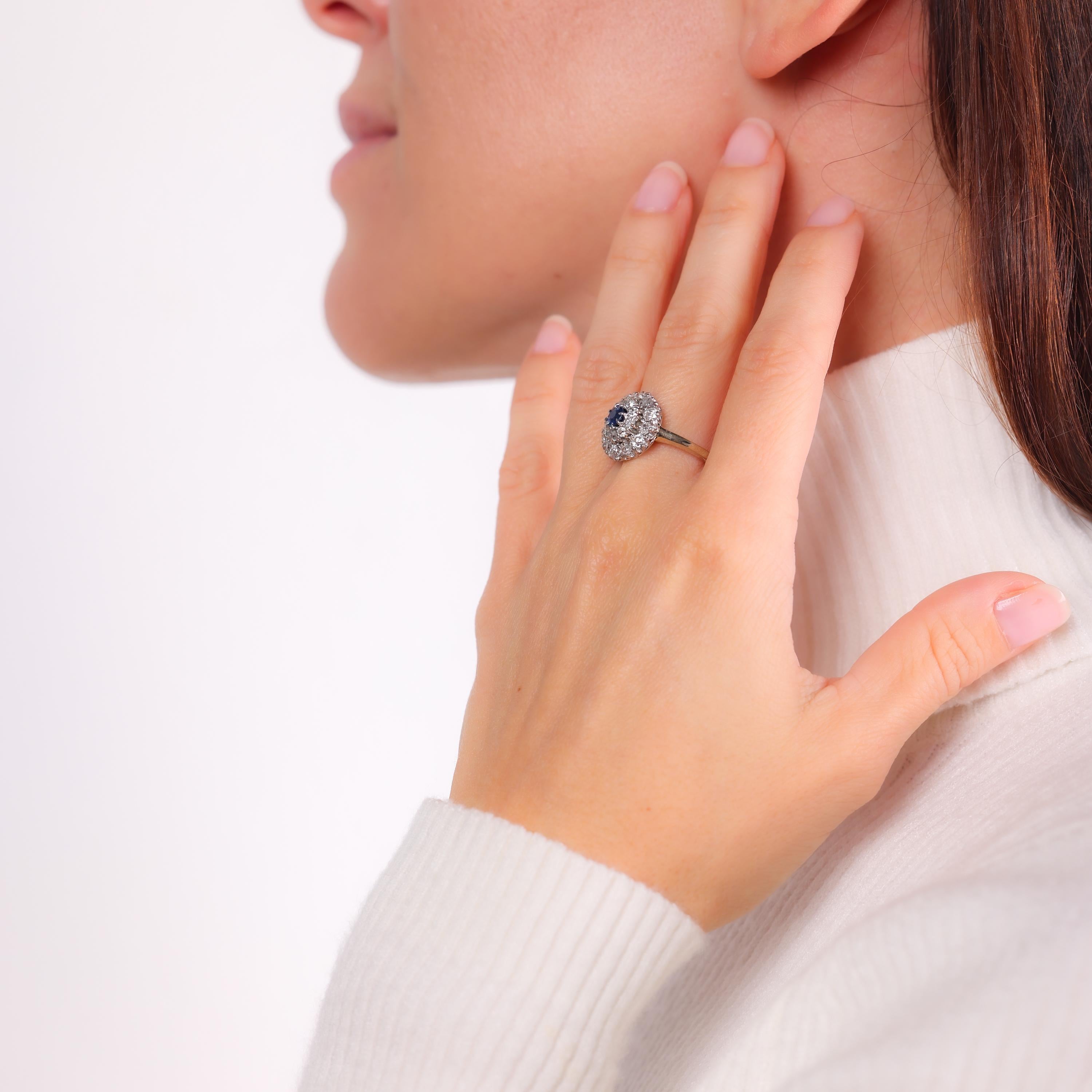 This antique cluster ring features a vibrant blue sapphire surrounded by sparkling old mine-cut diamonds, beautifully set on an 18k yellow gold band. A unique blend of 19th-century craftsmanship and 1980s refinement.

Center stone: Round brilliant