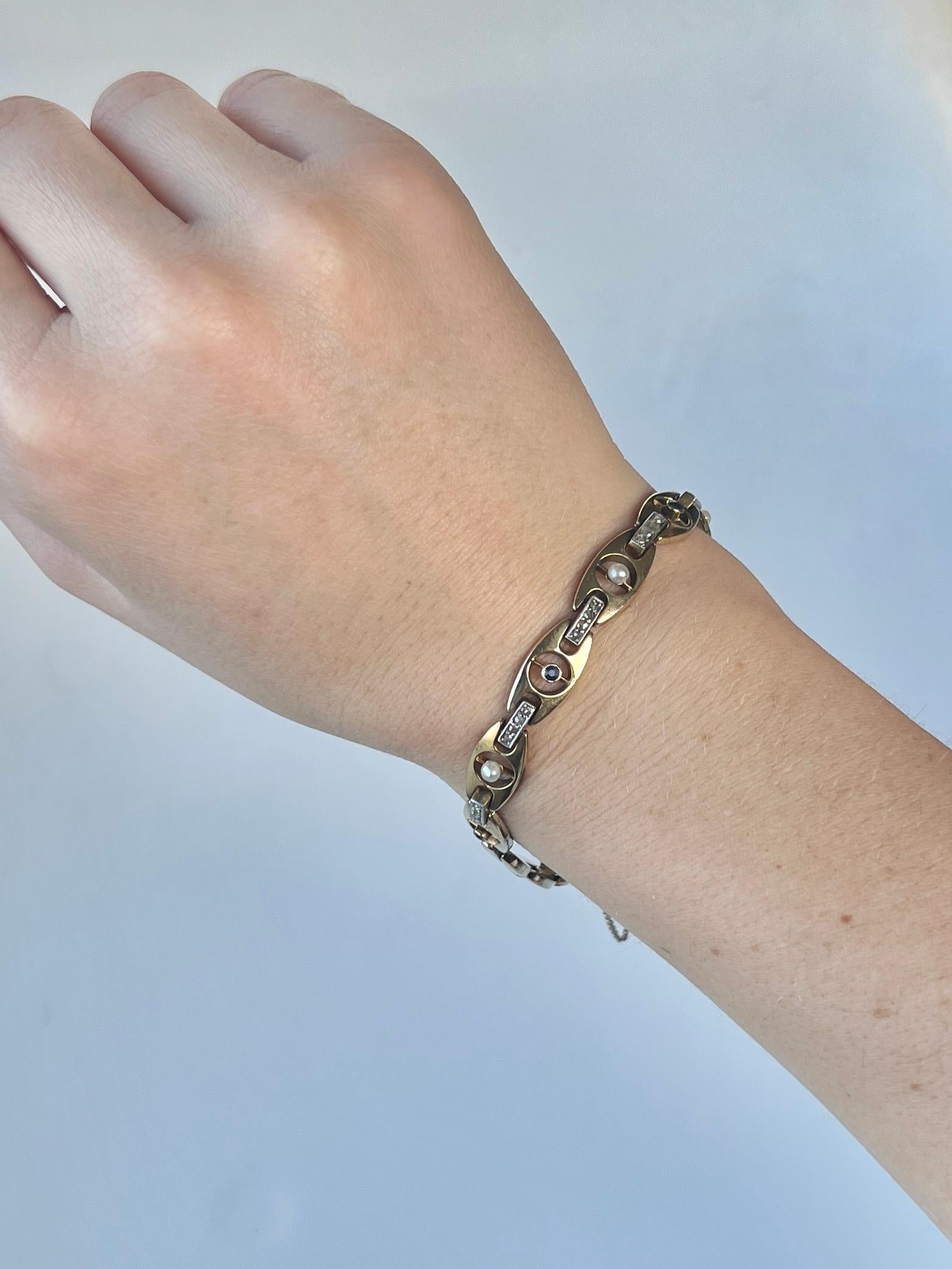 This bracelet holds sapphires and pearls in the glossy gold links. Connecting these links are panels with rose cut diamonds set in platinum. The four sapphires total 20pts and the rose cut diamond total of this bracelet is 48pts. 

Length:
