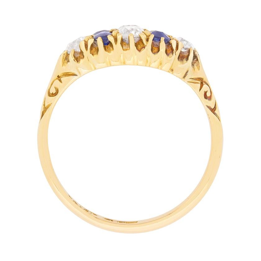 This original 1920s era diamond and sapphire cluster ring centres a pair of vertically set old cut diamonds between a pair of vertically set old cut sapphires, and a similarly-sized diamond at each shoulder.

Handmade in 18 carat yellow gold, this