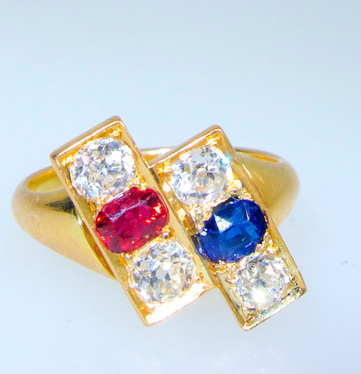Antique and unusual, this ring is 18K and possesses a fine sapphire and a fine ruby, set side by side in an unusual twist to the classic moi et toi motif.  The fine natural sapphire and ruby each weigh approximately .33 cts.  The fine old cut four