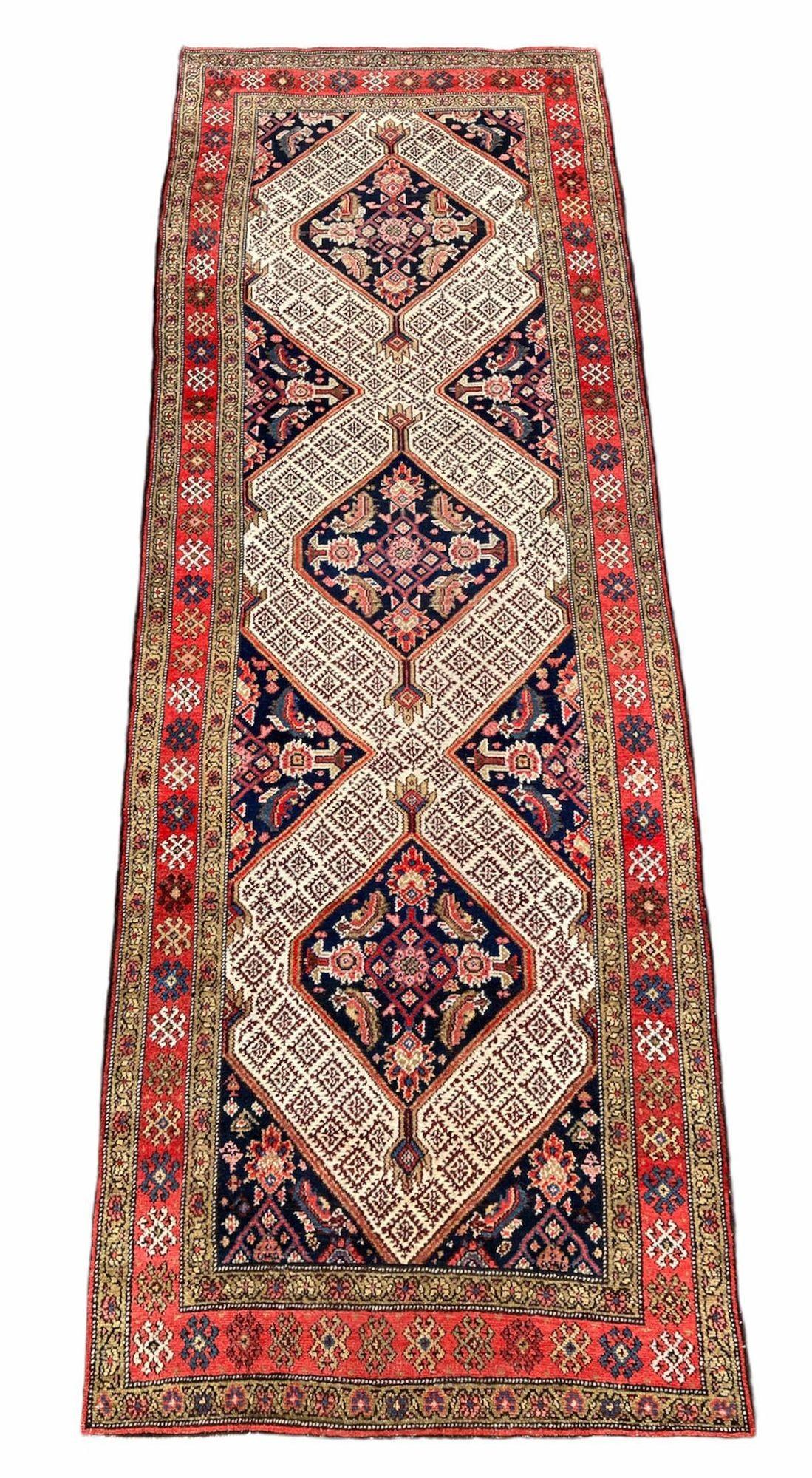 A beautiful antique Sarab runner, handwoven circa 1910 with a 3 medallion geometrical design on a deep indigo field and fabulous secondary colours. A lovely wide runner ideal for an entrance or wide hallway.
Size: 3.18m x 1.10m (10ft 5in x 3ft