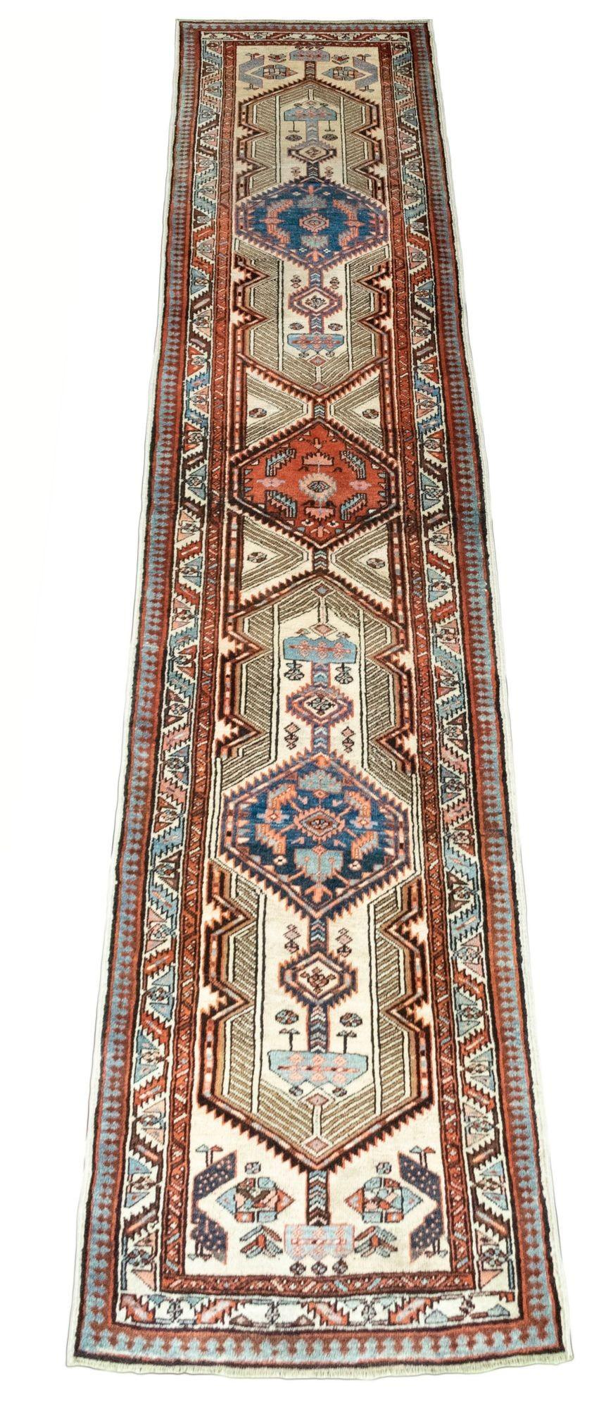 A beautiful vintage Sarab runner, handwoven circa 1920. The design features 3 geometrical medallions on an ivory field and similar border with secondary colours of blues, reds and pinks.
Size: 4.29m x 0.90m (14ft 1in x 3ft)
This rug is in good