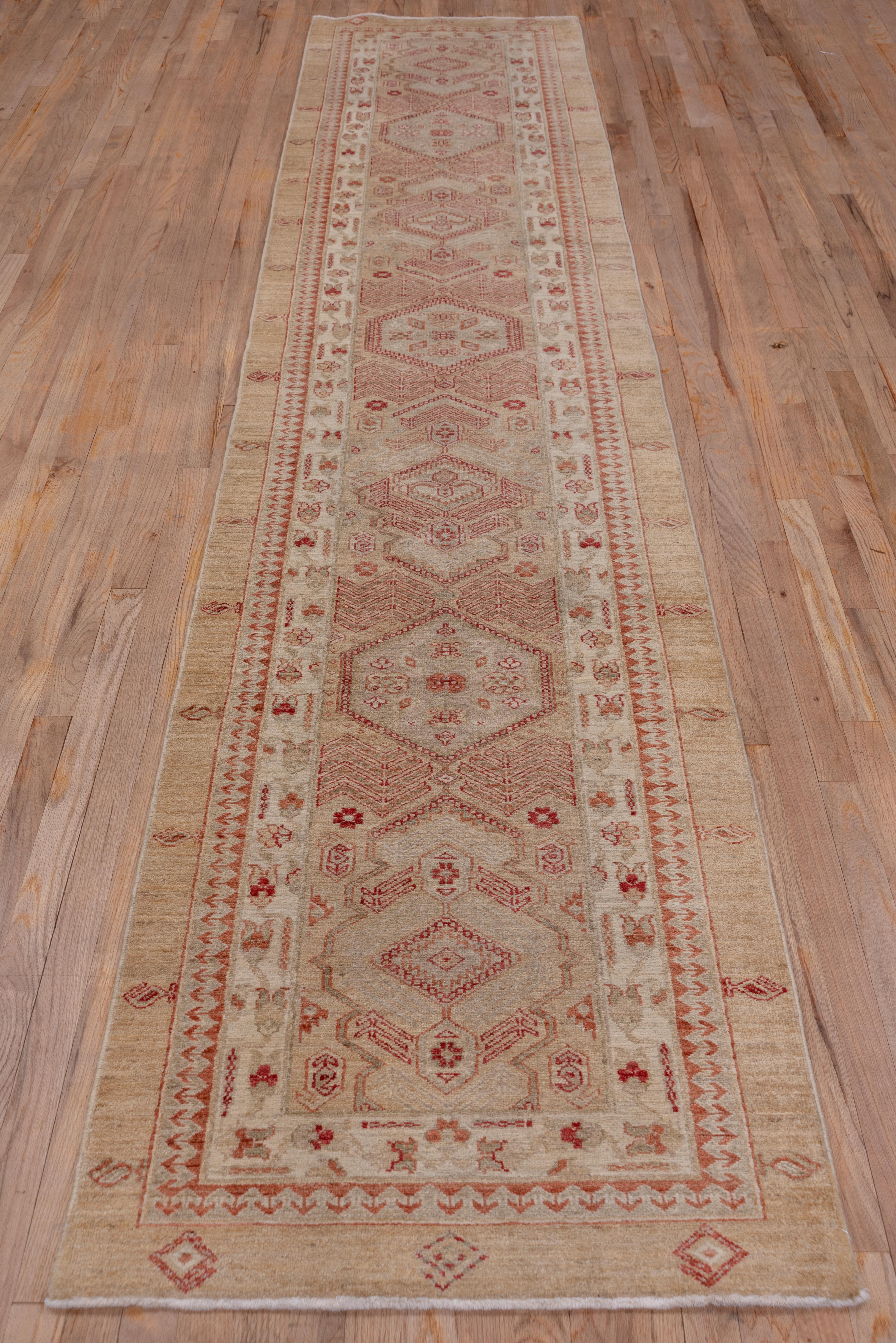 This lightly toned recent NW Persian Sarab runner displays alternating hexagons and cartouches along the central axis of the beige-camel field. Herringbone plants adorn the field sides along with small bottehs. The outer border shows sporadic botehs