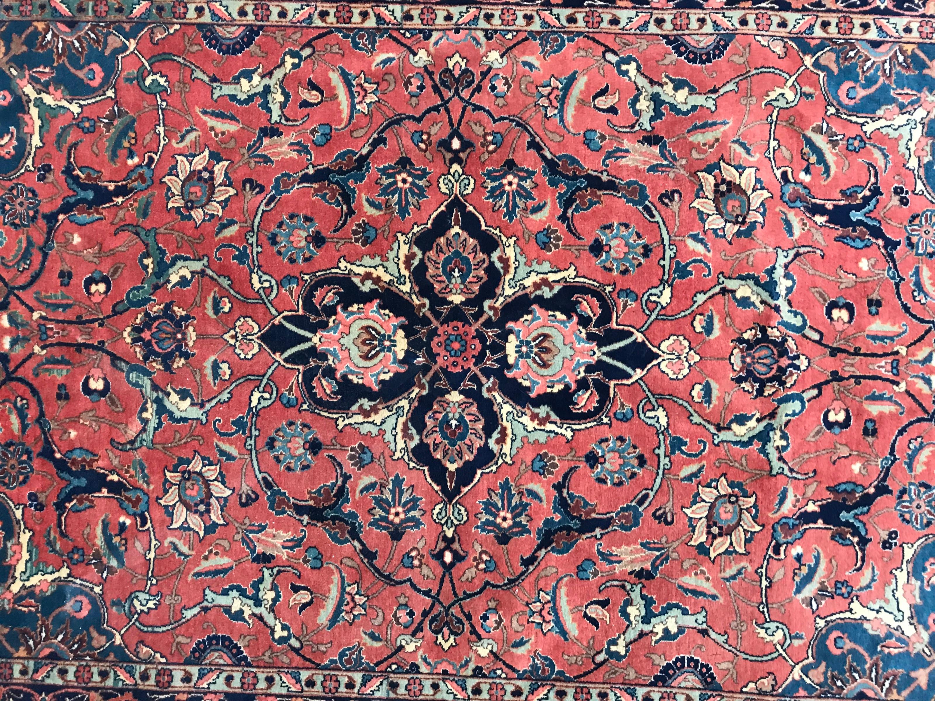Exquisiter antiker Teppich mit einem atemberaubenden floralen Medaillonmuster in der Mitte und fesselnden natürlichen Farben, darunter Rot-, Blau- und Rosatöne. Sorgfältig von Hand geknüpft mit Wollsamt auf einer strapazierfähigen Baumwollgrundlage.