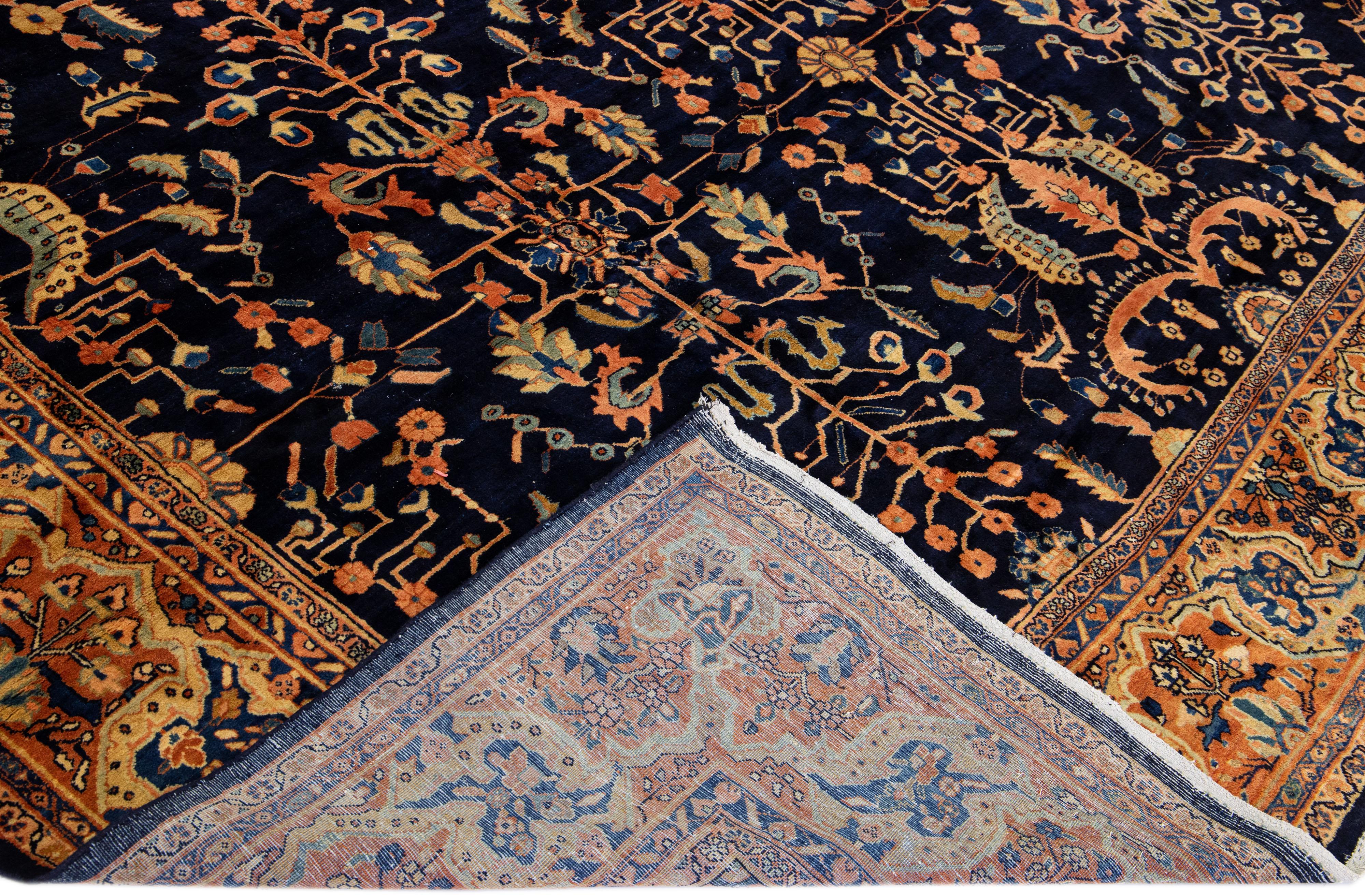 Beautiful Antique Farahan hand-knotted wool rug with a dark blue field. This Persian rug has a rusted-designed frame with multi-color accents on a Classic floral design.

This rug measure: 11'2