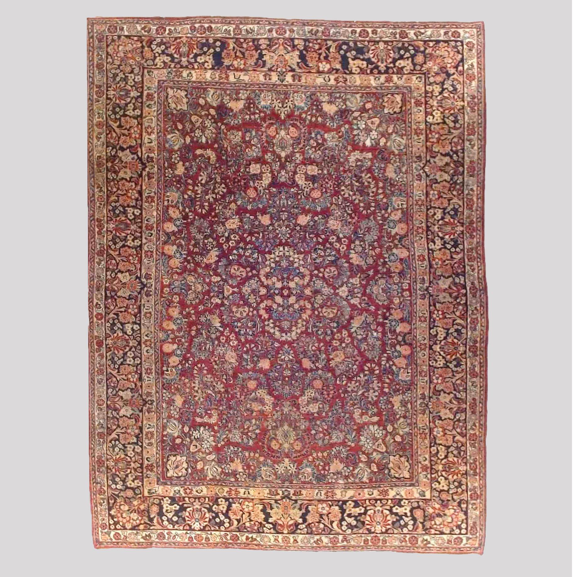 An antique Sarouk oriental carpet offers wool construction with central medallion and allover floral and foliate design on red ground, c1930

Measures - 142