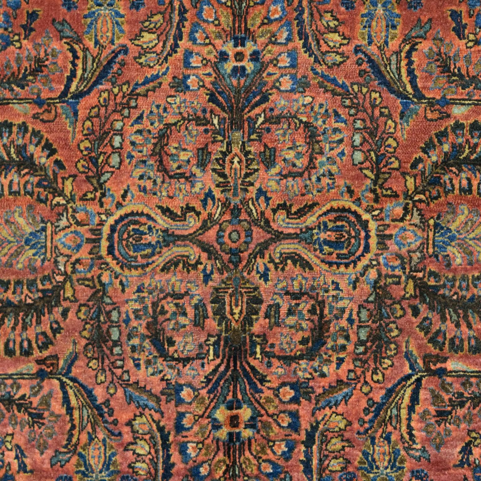 Woven in Iran, this hand-knotted Sarouk carpet measures 4’ x 6’5” and belongs to the Antique Collection. Crafted using a traditional Persian weave, this antique Sarouk has a soft pile and a durable foundation. The carpet’s rich red background, along