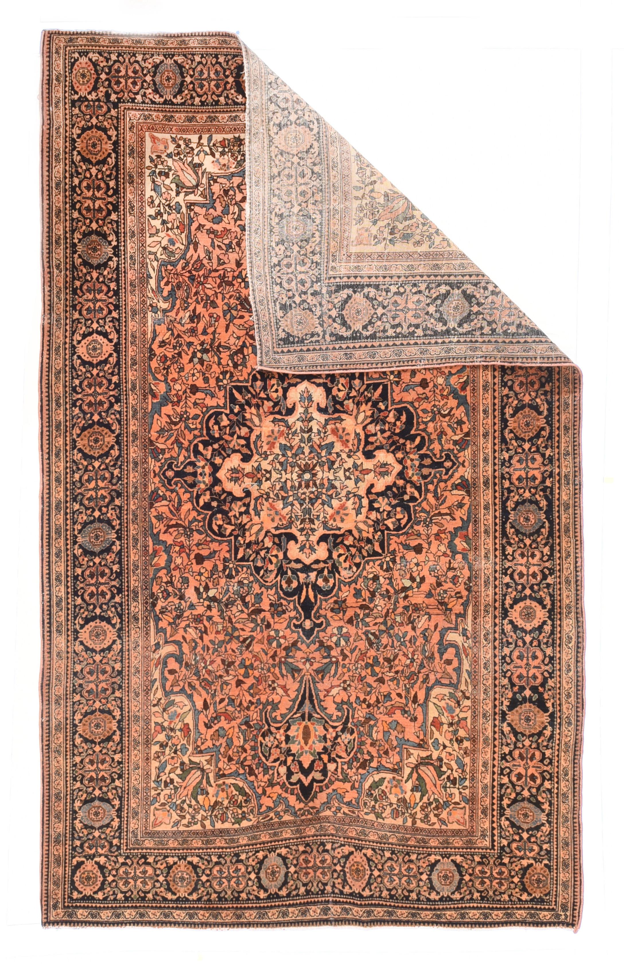 Tapis Sarouk ancien 4'1'' x 6'6''. Cet objet de la province d'Arak, datant du début du XXe siècle, représente un champ de roses envahi de petites fleurs et de vignes, qui soutient un médaillon de la marine, raide et lobé, avec d'audacieux pendentifs
