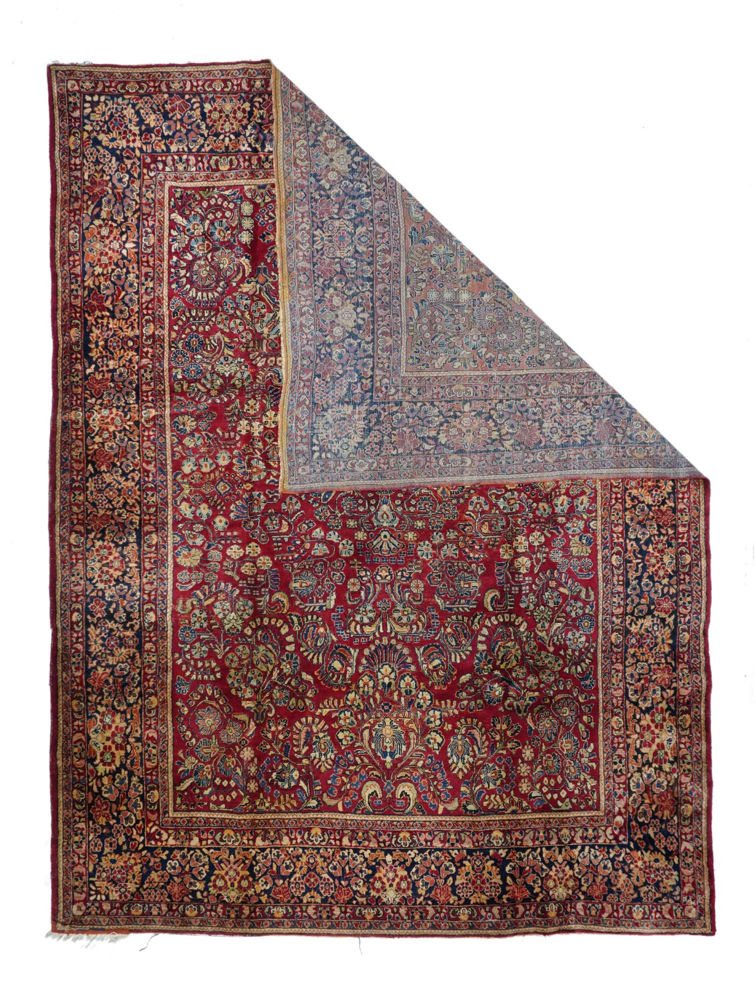 With the more closely covered red field characteristic of later examples of the ”American Sarouk” genre, this solidly woven carpet features a wide variety of detached floral sprays accented in straw, cream, green, navy and dark blue. Navy border