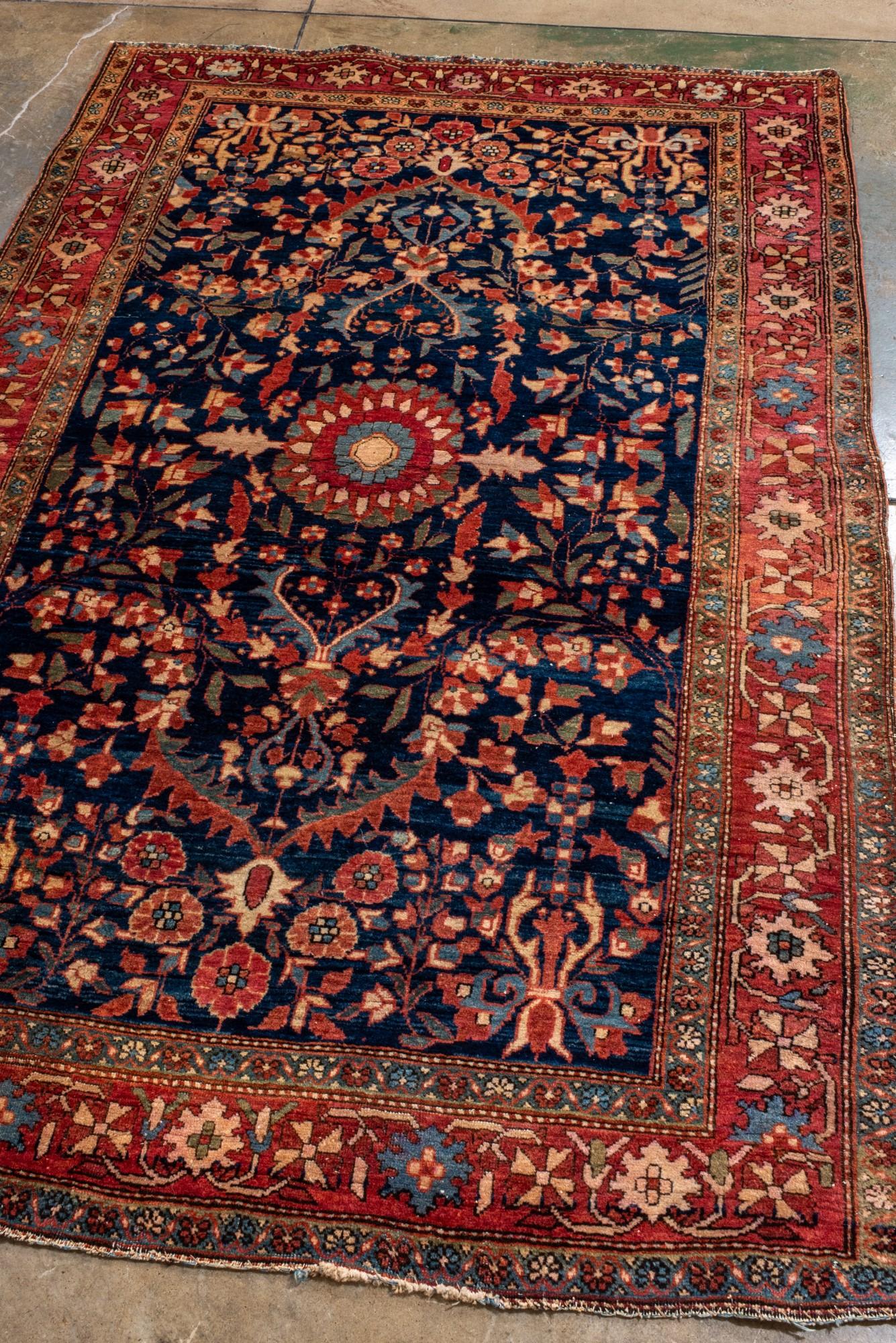 Perse Tapis Sarouk ancien avec un champ de marine, bordure rouge et médaillon rond en vente