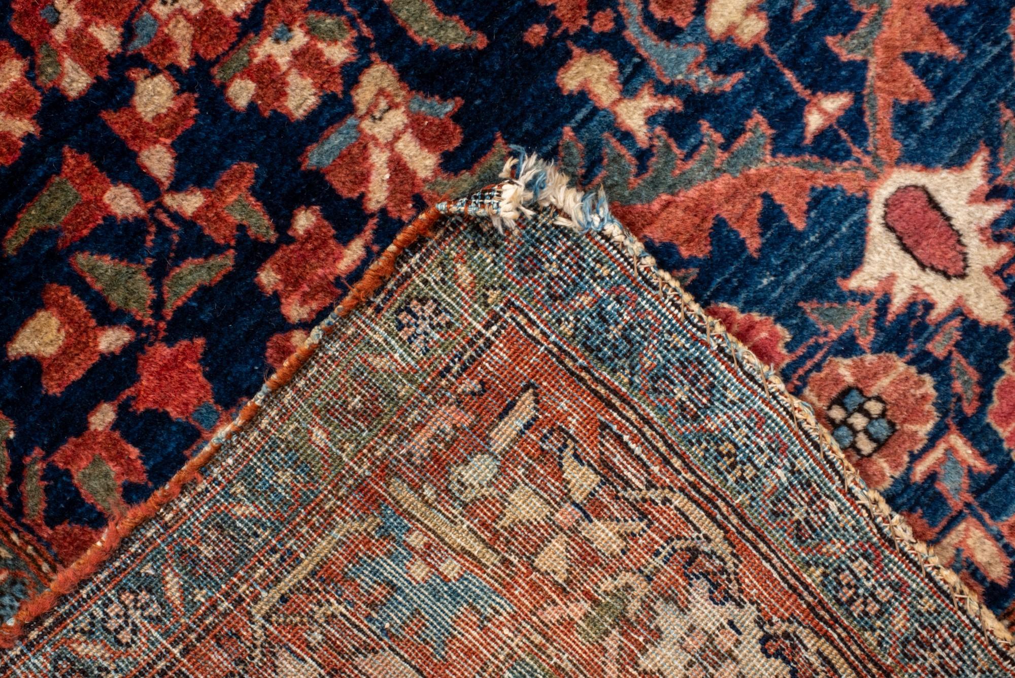 20ième siècle Tapis Sarouk ancien avec un champ de marine, bordure rouge et médaillon rond en vente