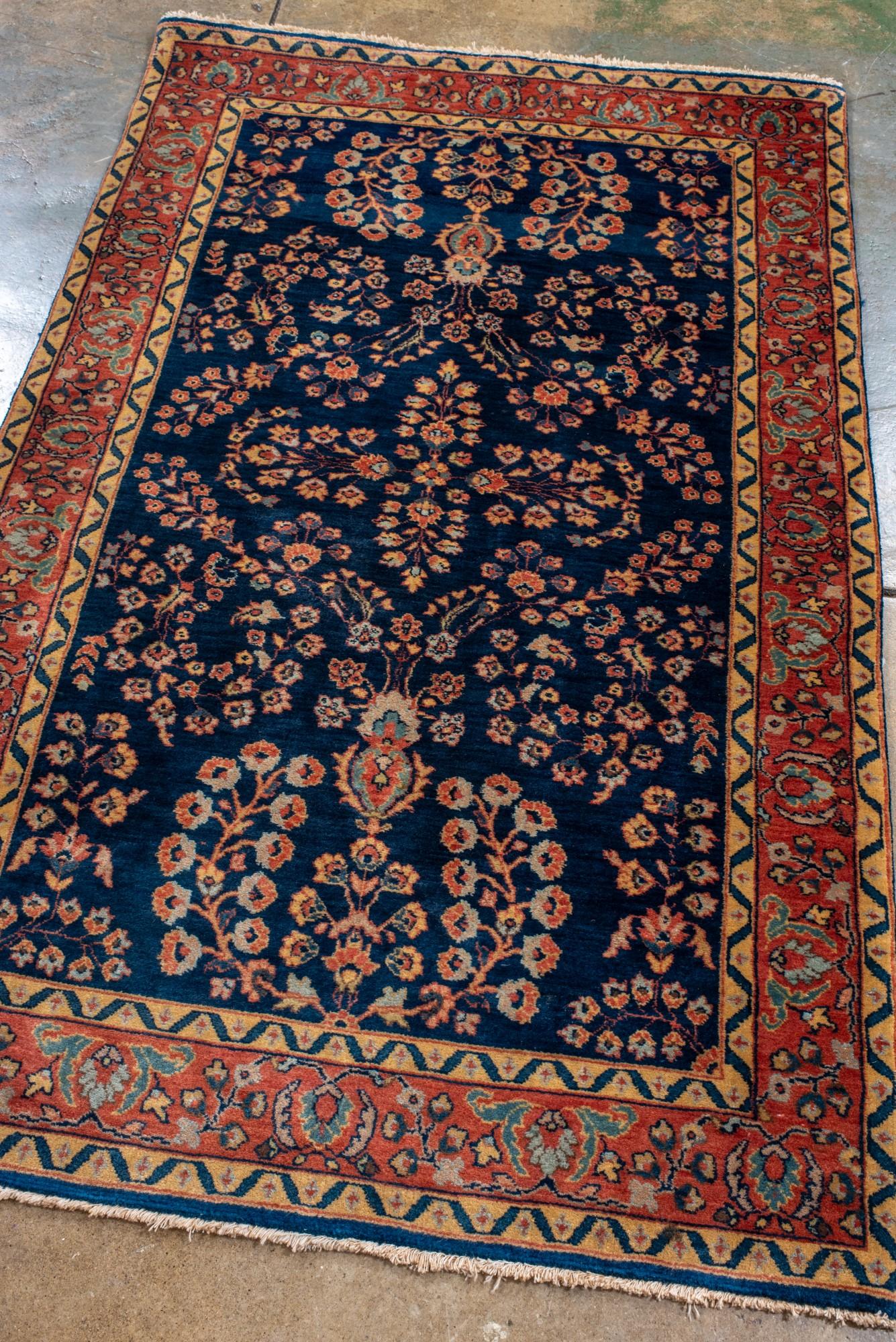 Sarouk antiguo con fondo azul marino y borde rojo Persa en venta